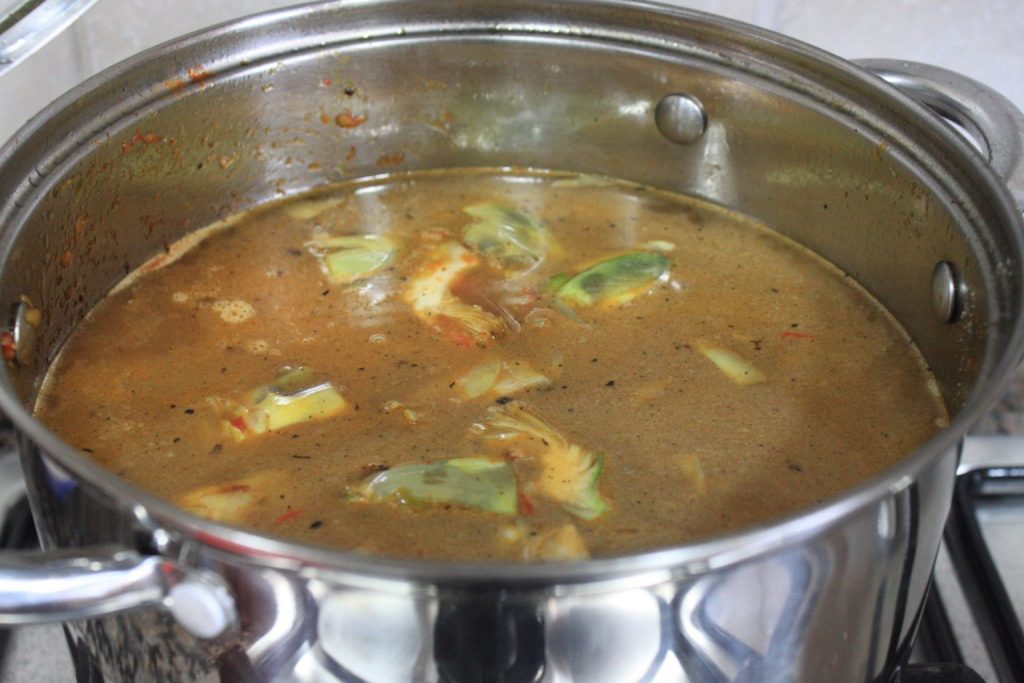 Cubriendo con agua el guiso de fideos con alcachofas y costilla