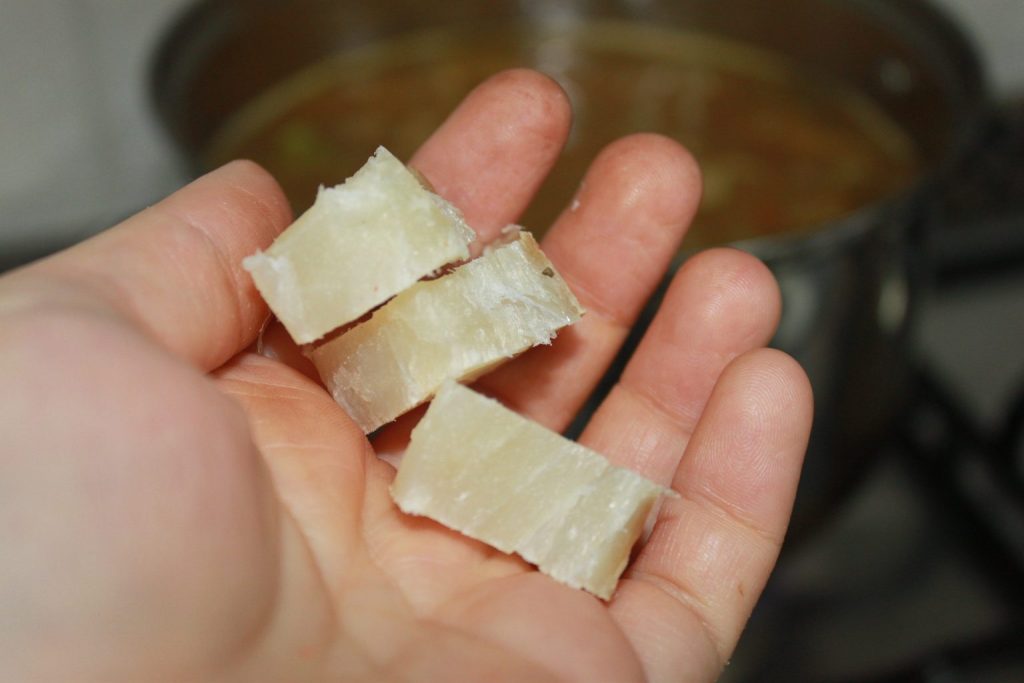 Añadiendo trozos de bacalao salado a los fideos a la cazuela para dar un sabor tradicional profundo