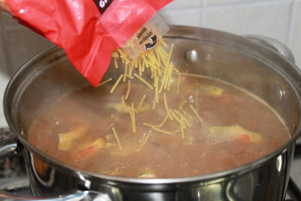 Añadiendo los fideos gruesos al caldo hierviendo