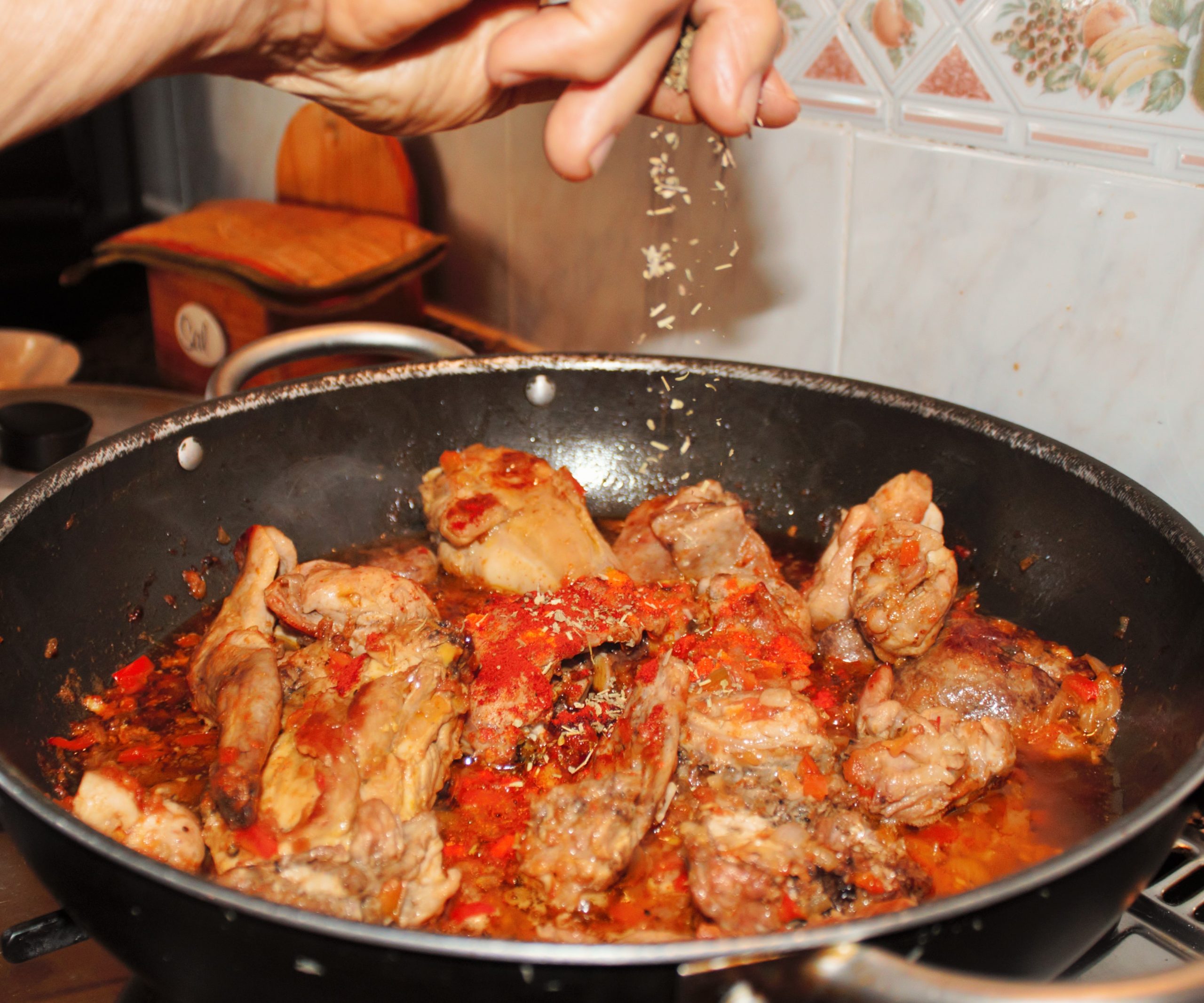 Añadiendo las finas hierbas al sofrito de conejo