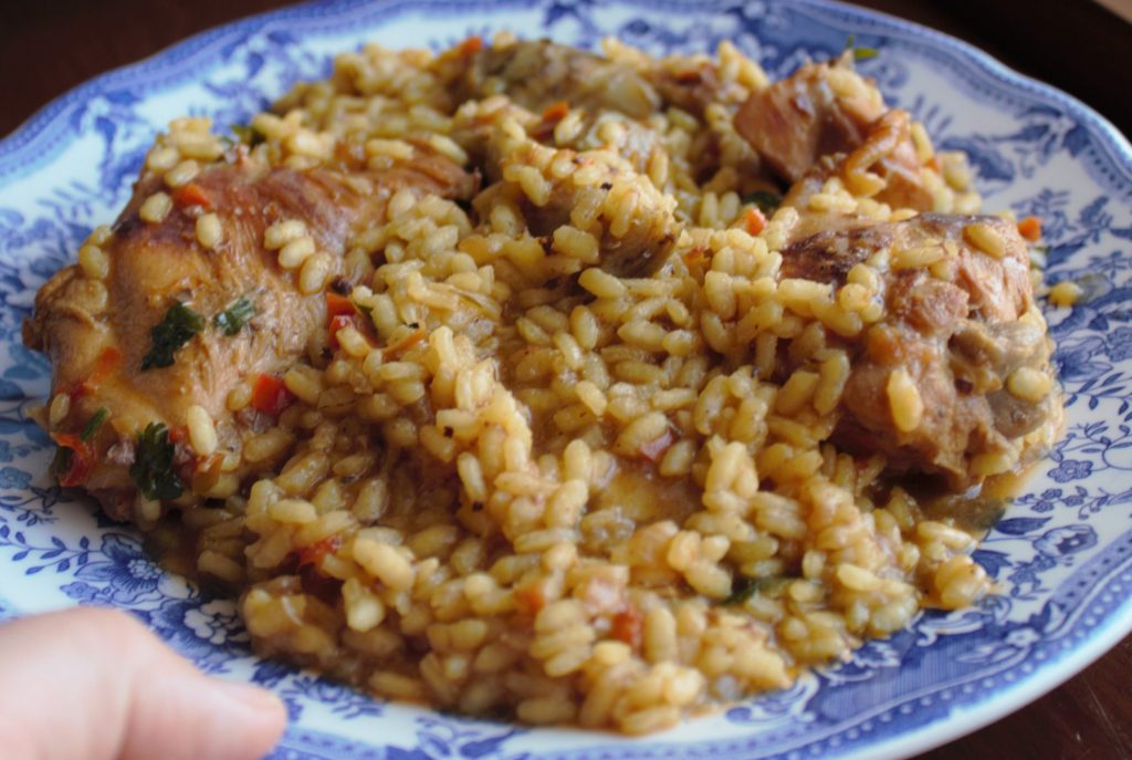 Plato de arroz de conejo y alcachofas servido en el plato