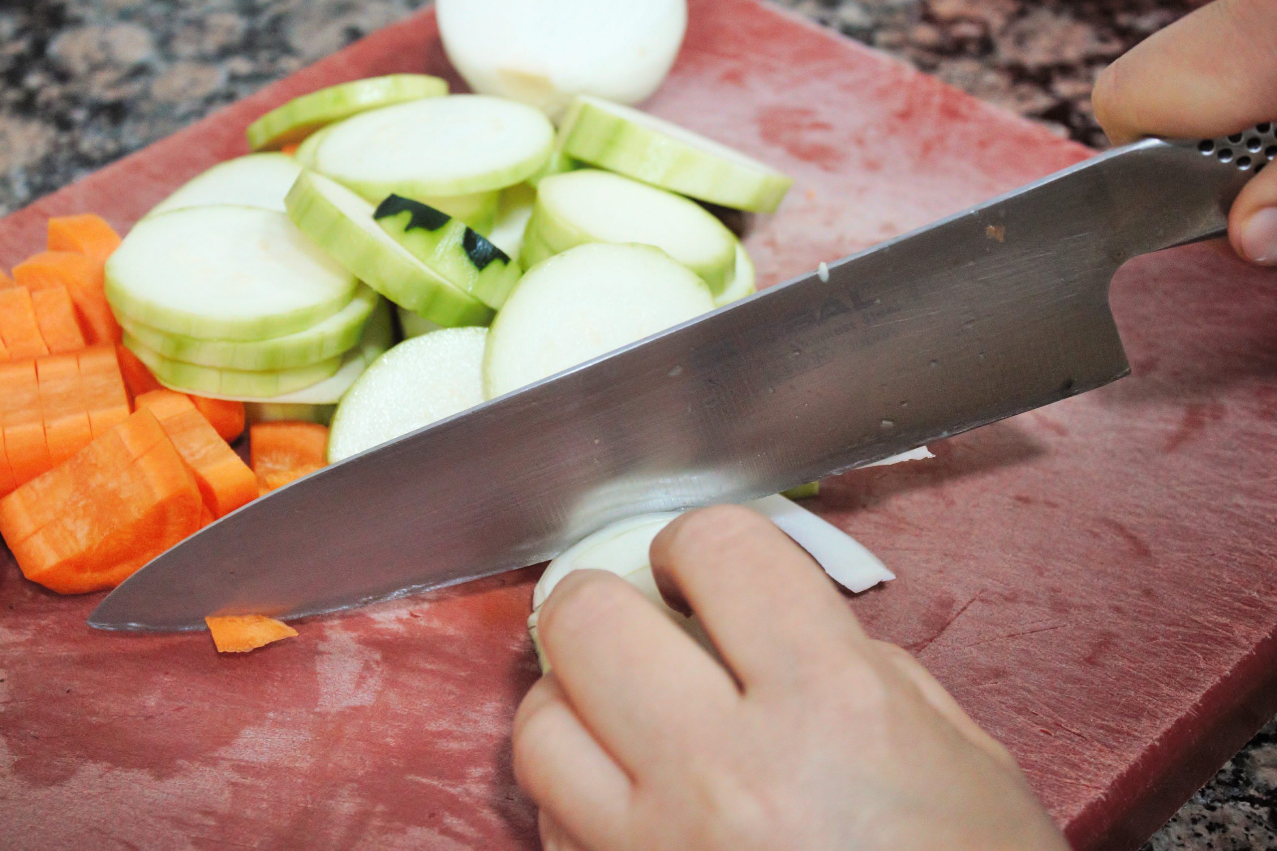 Verduras frescas de temporada troceadas sobre una tabla de madera rústica para preparar una crema casera.