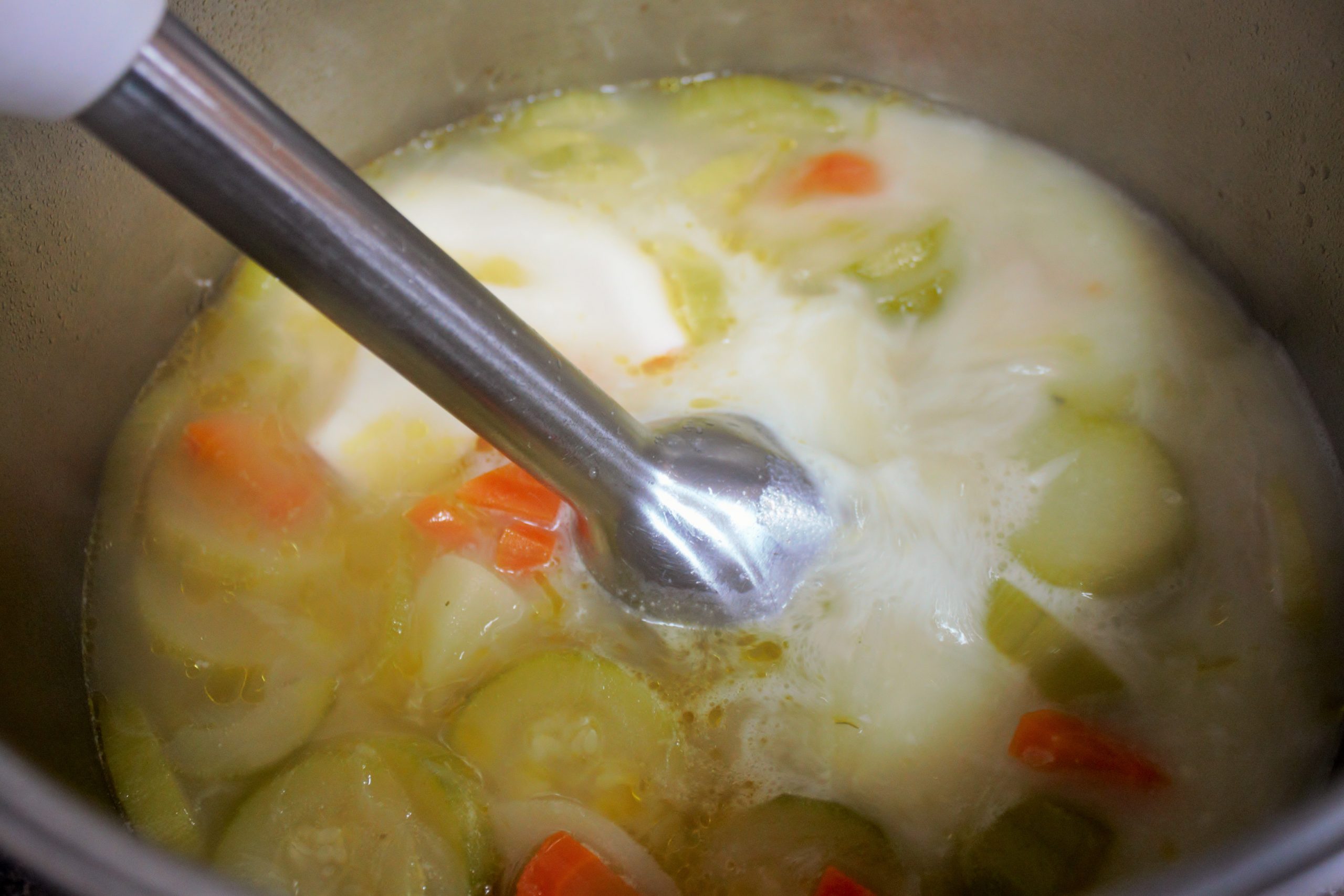 Textura cremosa y aterciopelada de una crema de verduras recién triturada en la cocina.