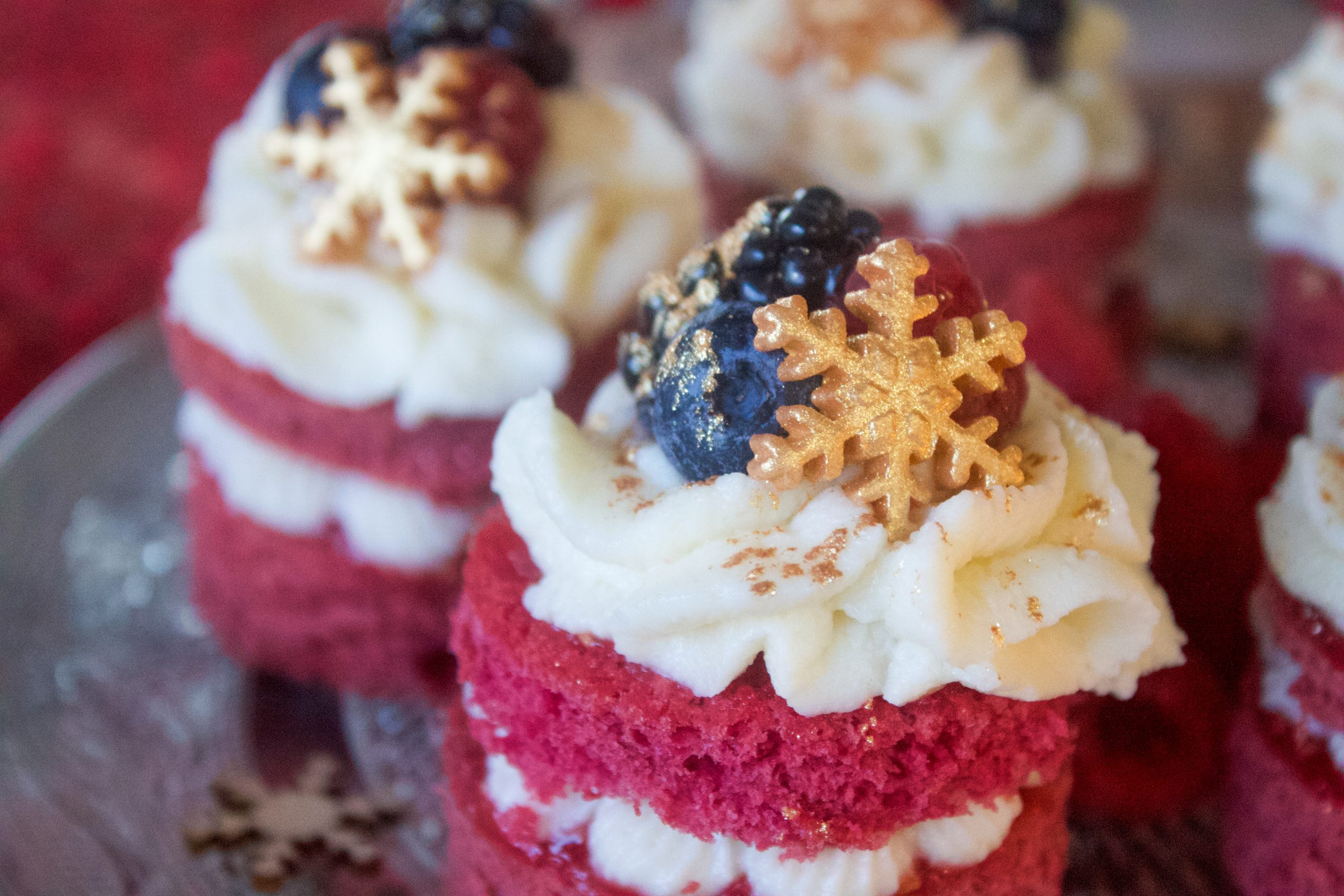 Mini pastelitos de frutos rojos con buttercream de queso y decoración navideña