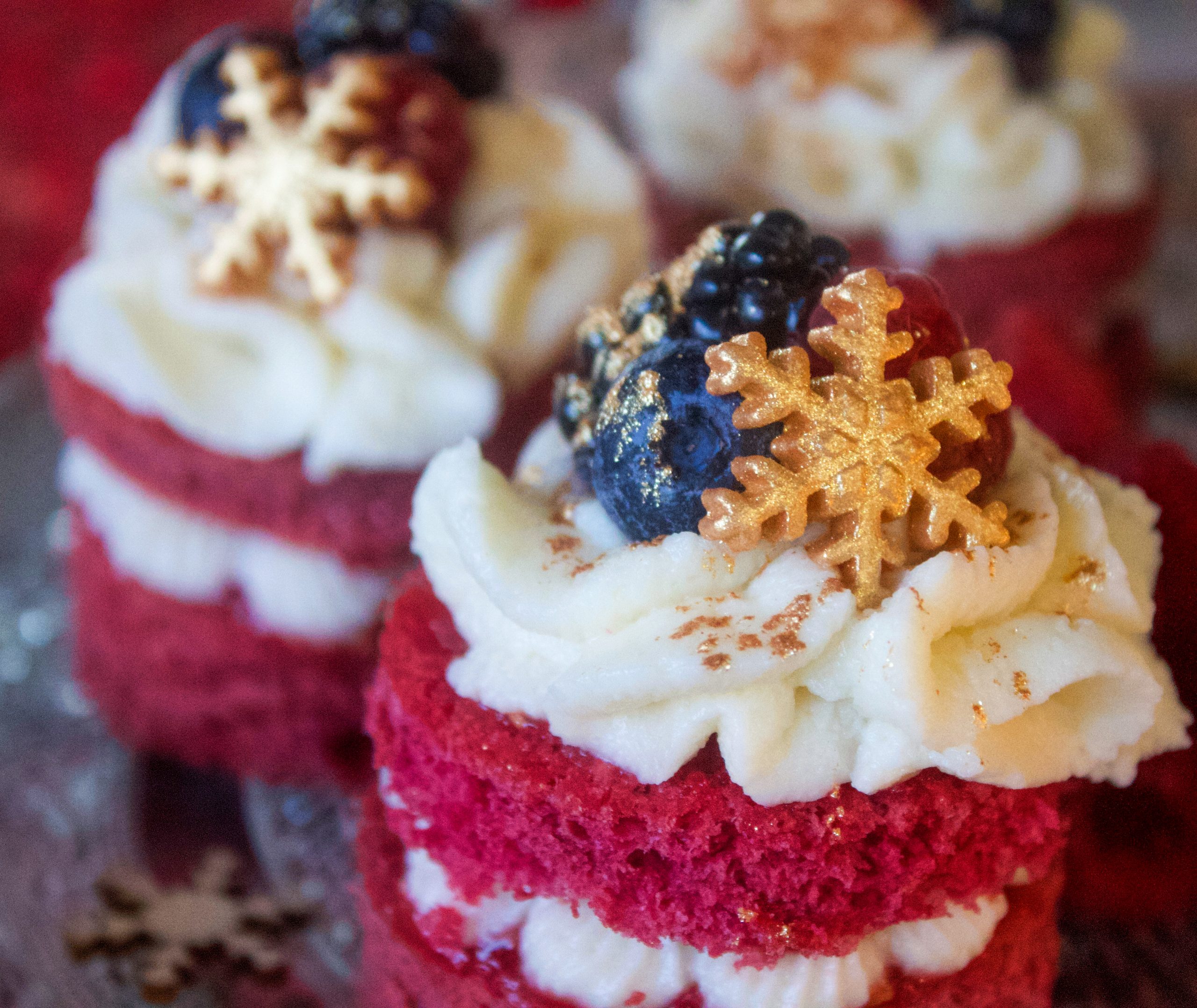 Mini pastelitos de frutos rojos con buttercream de queso y decoración navideña