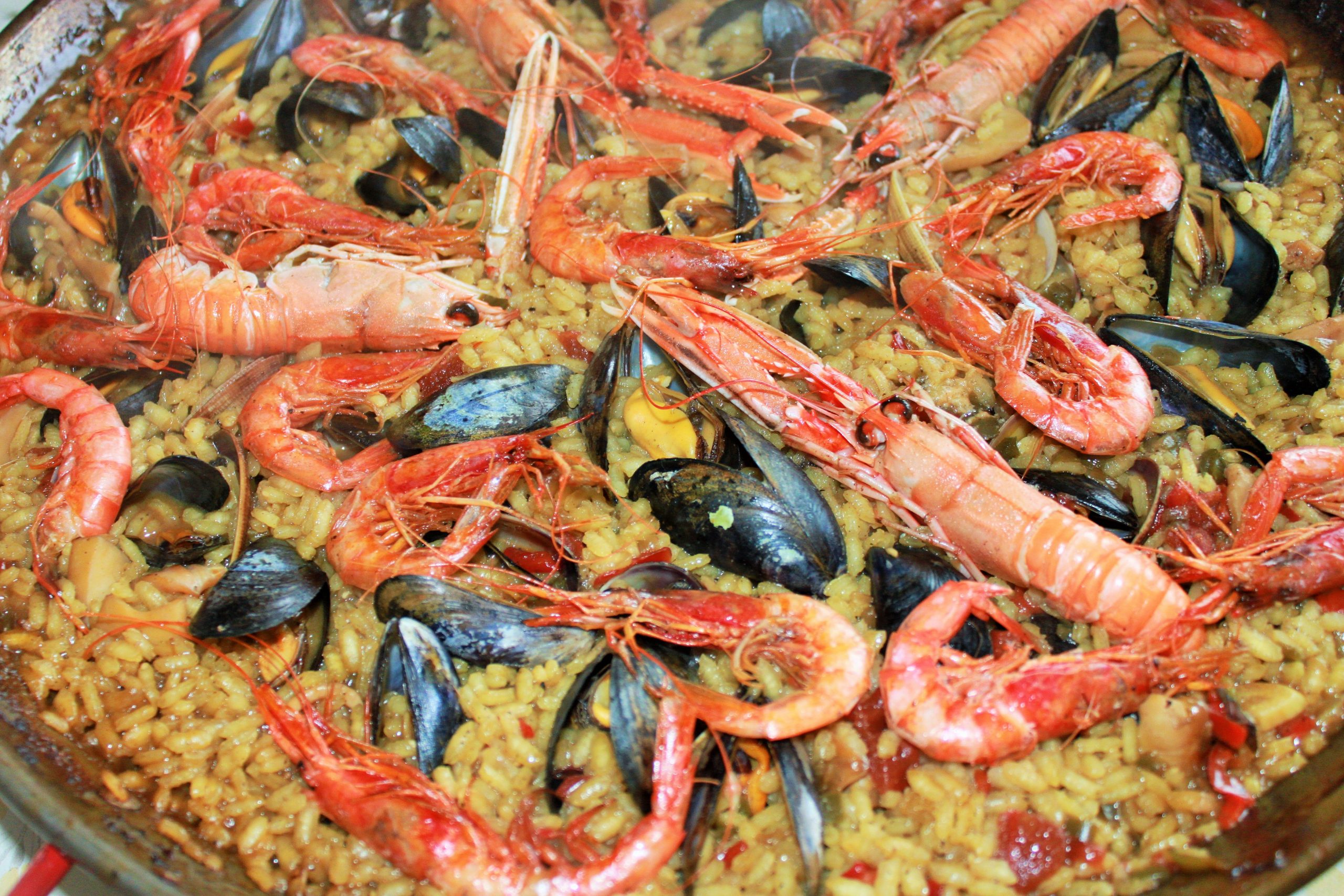 Paella de arroz de marisco con gambas, mejillones y calamares reci&eacute;n servida.