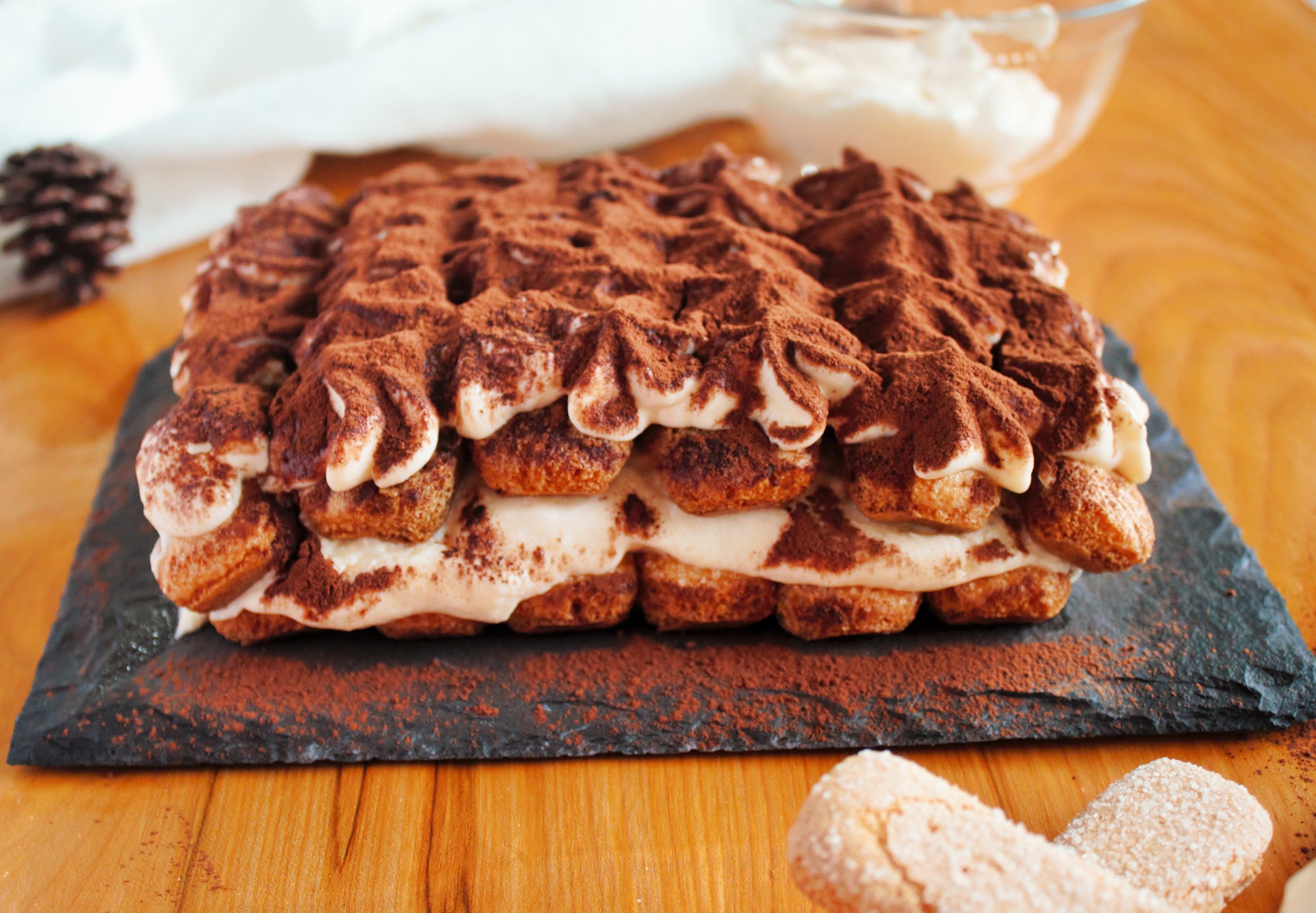 Tiramisú italiano casero con capas de crema de mascarpone, bizcochos empapados en café y cacao puro espolvoreado por encima.