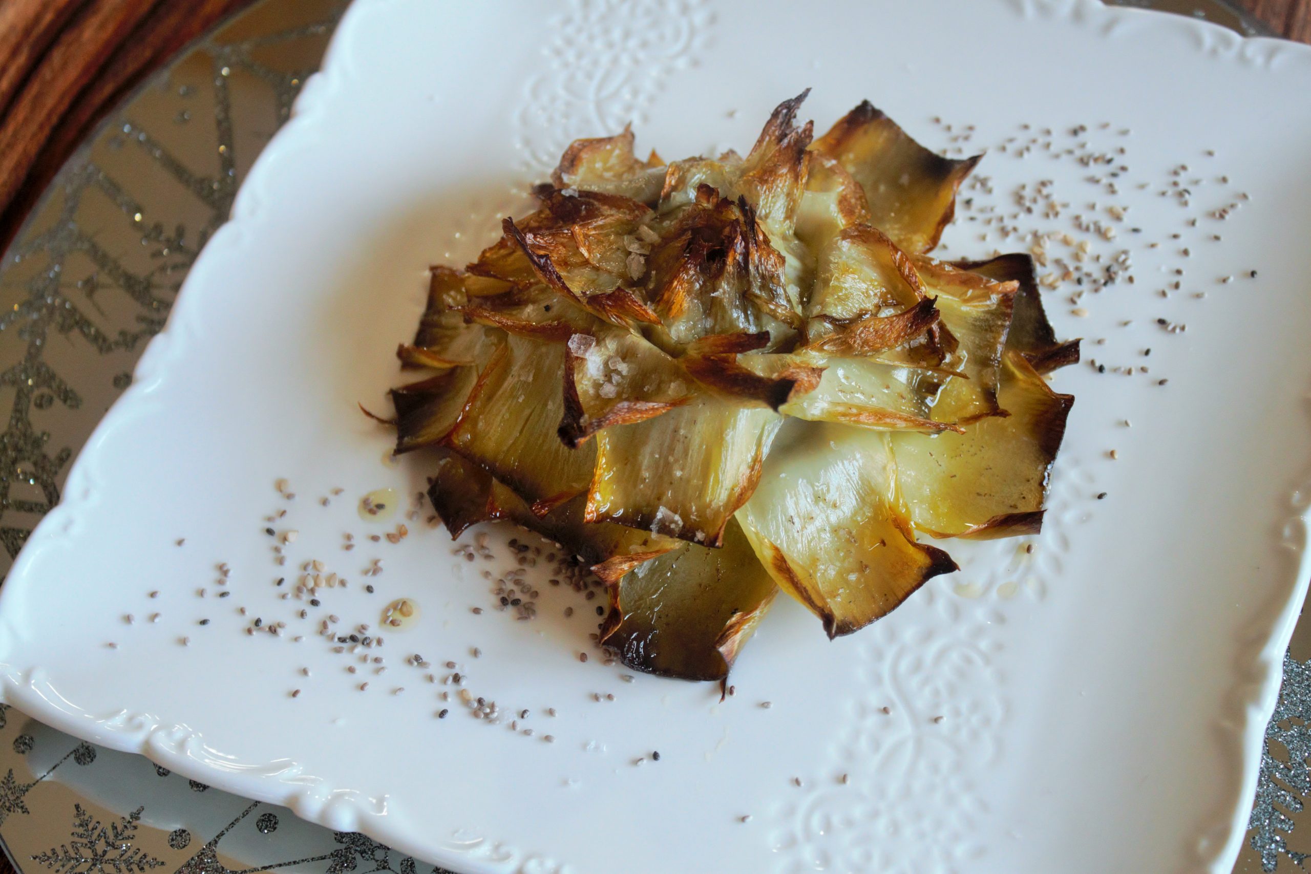 Primer plano de la textura tierna del corazón de una alcachofa confitada recién salida del horno.