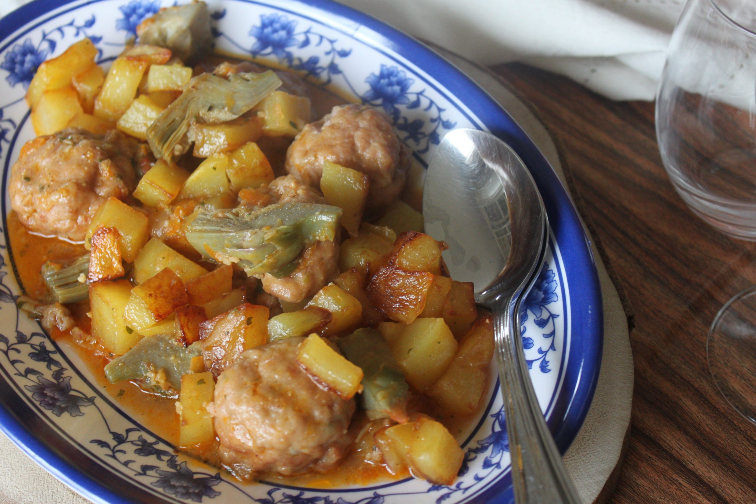 Cazuela de albóndigas con corazones de alcachofas, patatas y sofrito tradicional.