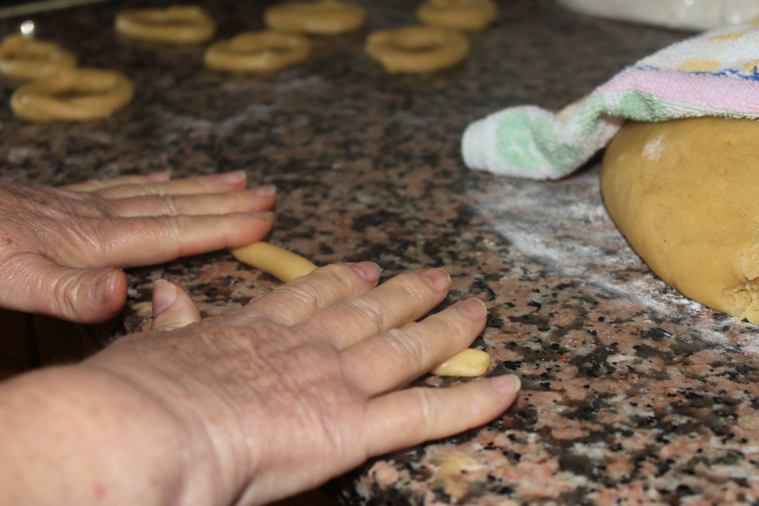 Manos estirando la masa para elaborar roscos de anís tradicionales paso a paso