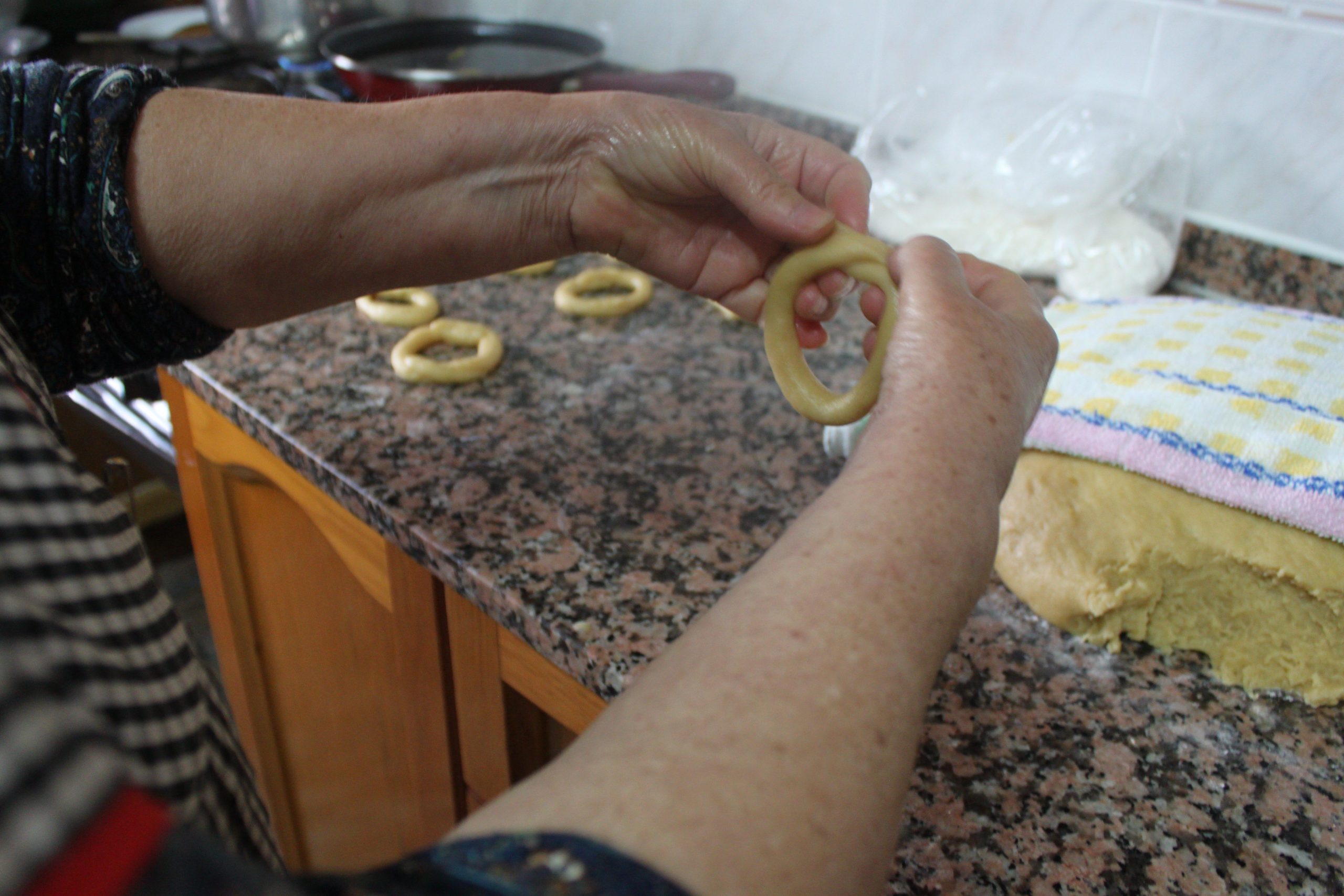 Cómo dar forma a los roscos de anís caseros uniendo los extremos de la masa.