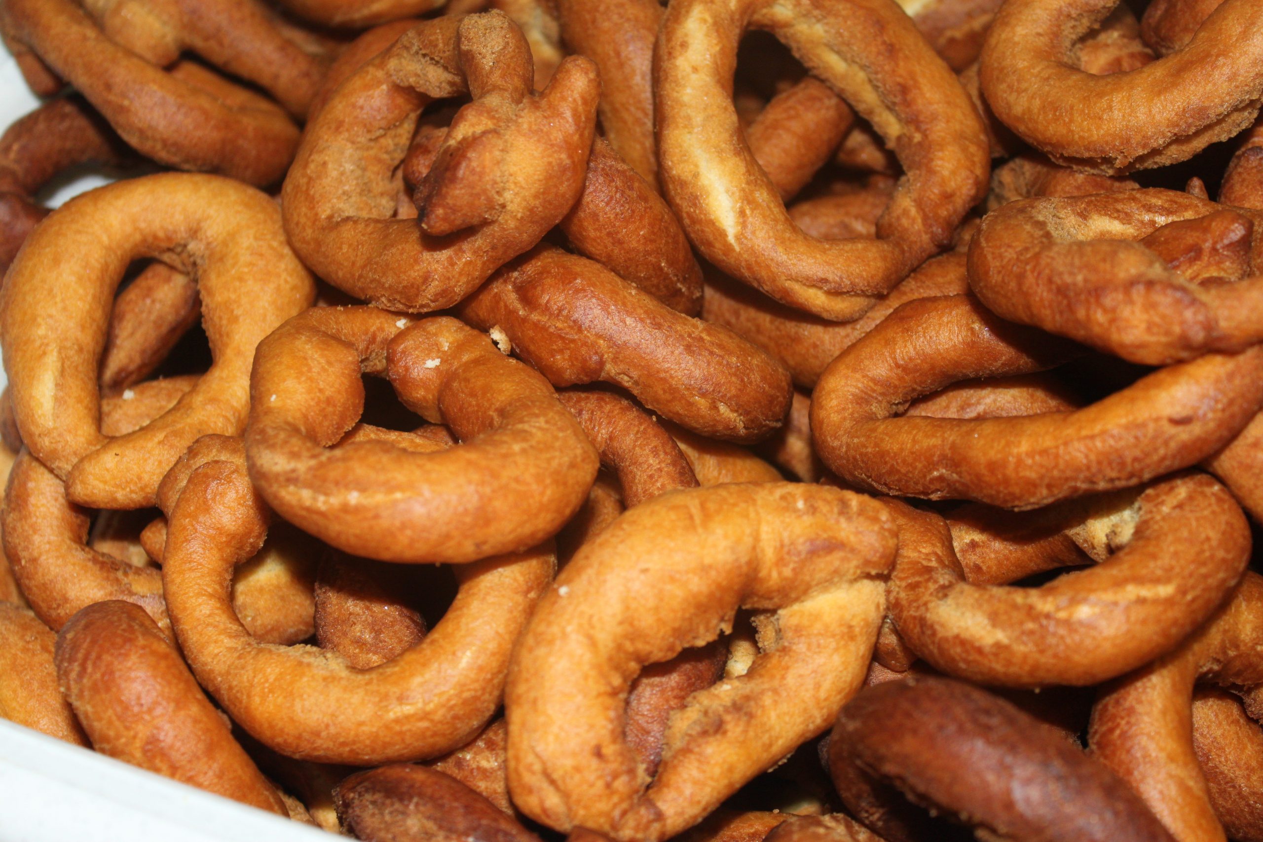 Roscos de anís caseros recién fritos antes de rebozarlos en azúcar.