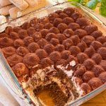 Bandeja de Tiramisú italiano casero con capas de crema de mascarpone, bizcochos empapados en café y cacao puro espolvoreado por encima.
