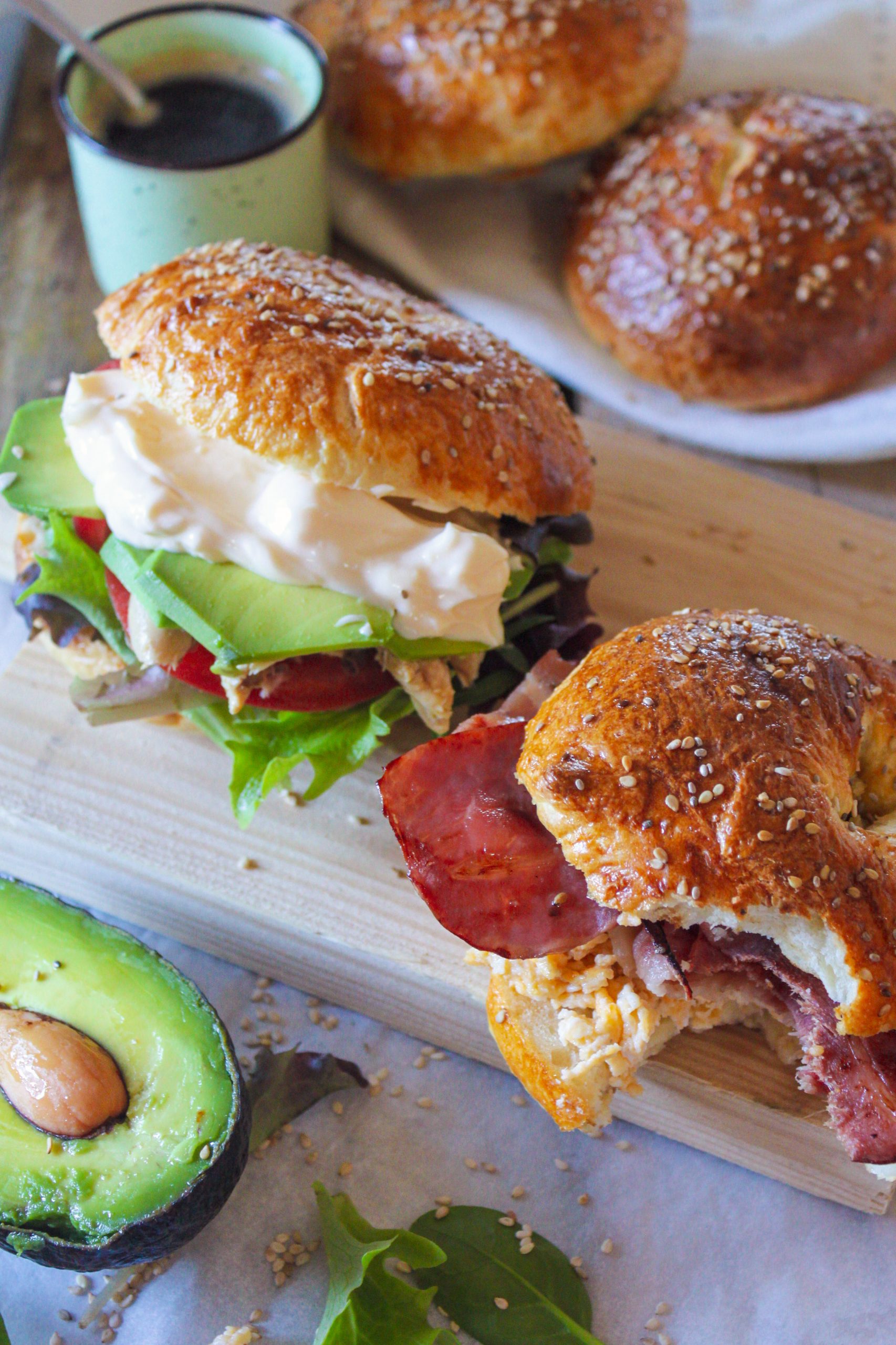 Bagel casero recién horneado con semillas de sésamo y amapola sobre una superficie de madera rústica, luz natural suave y ambiente cálido de cocina.