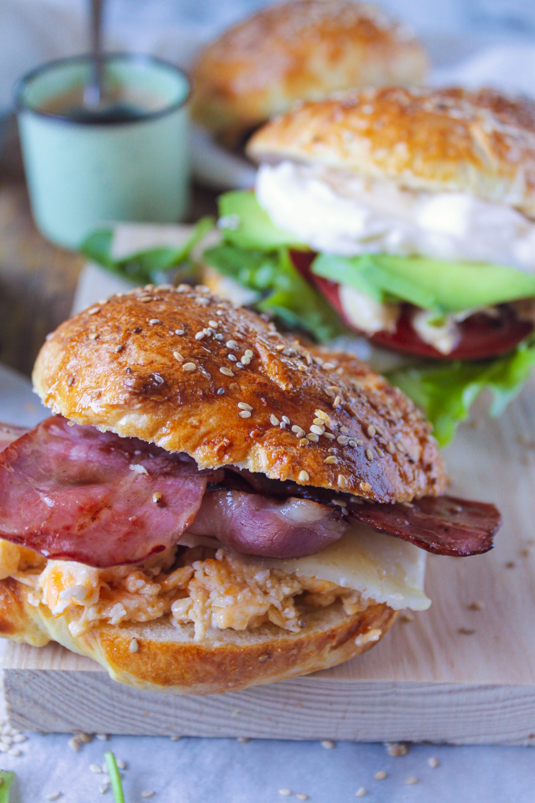 Bagel casero reci&eacute;n horneado con semillas de s&eacute;samo y amapola sobre una superficie de madera r&uacute;stica, luz natural suave y ambiente c&aacute;lido de cocina.