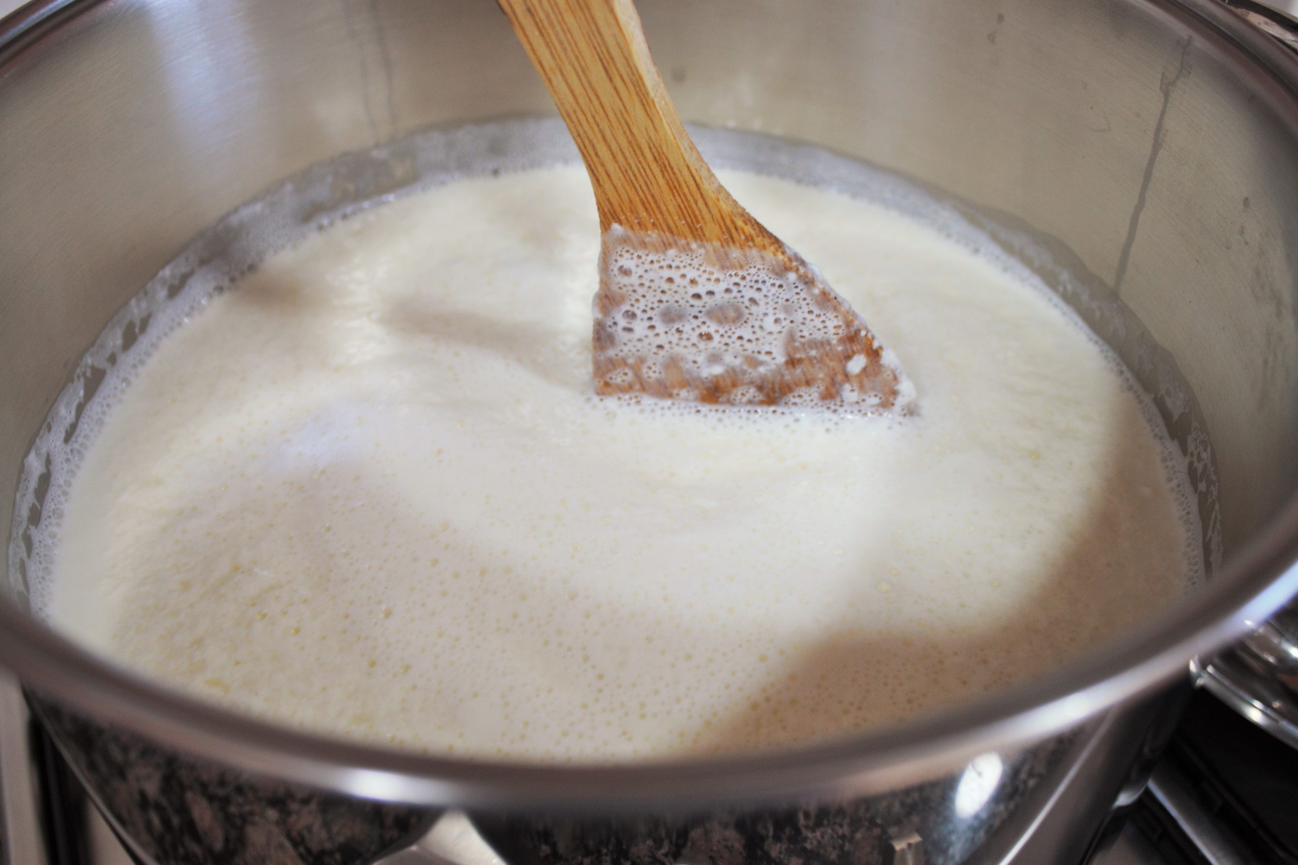 Removiendo la leche cuando empieza a soltar el suero.