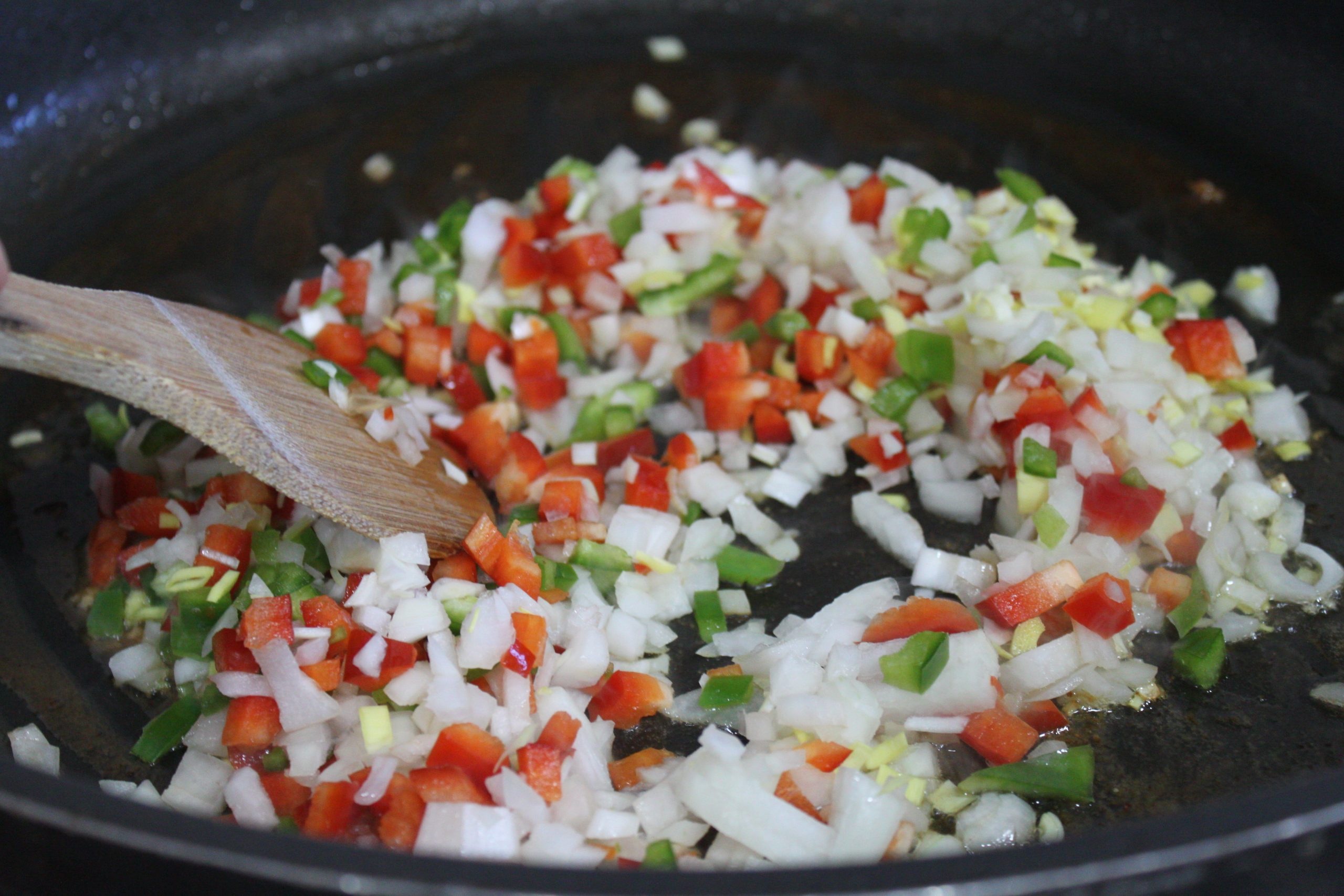 Sofrito de verduras pochándose a fuego lento en la cazuela para la base de la zarzuela.