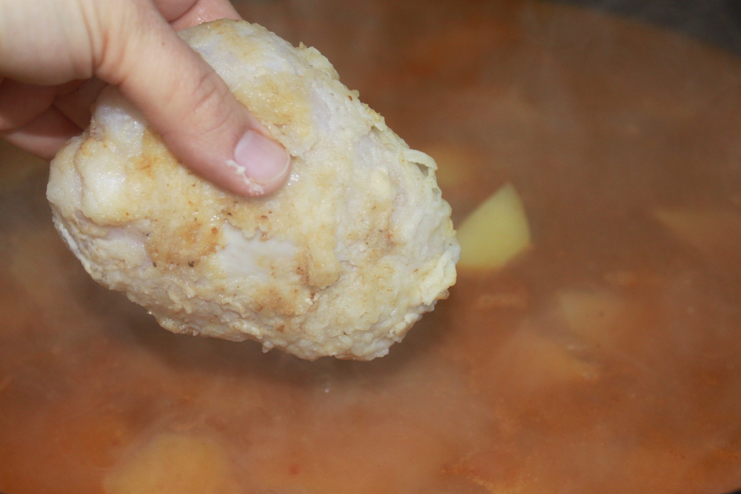 Patatas y trozos de rape cocinándose juntos en la salsa de la zarzuela.
