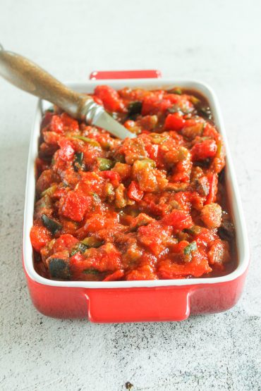 Primer plano de Sanfaina con pavo terminada, con brillo del aceite y hierbas provenzales.