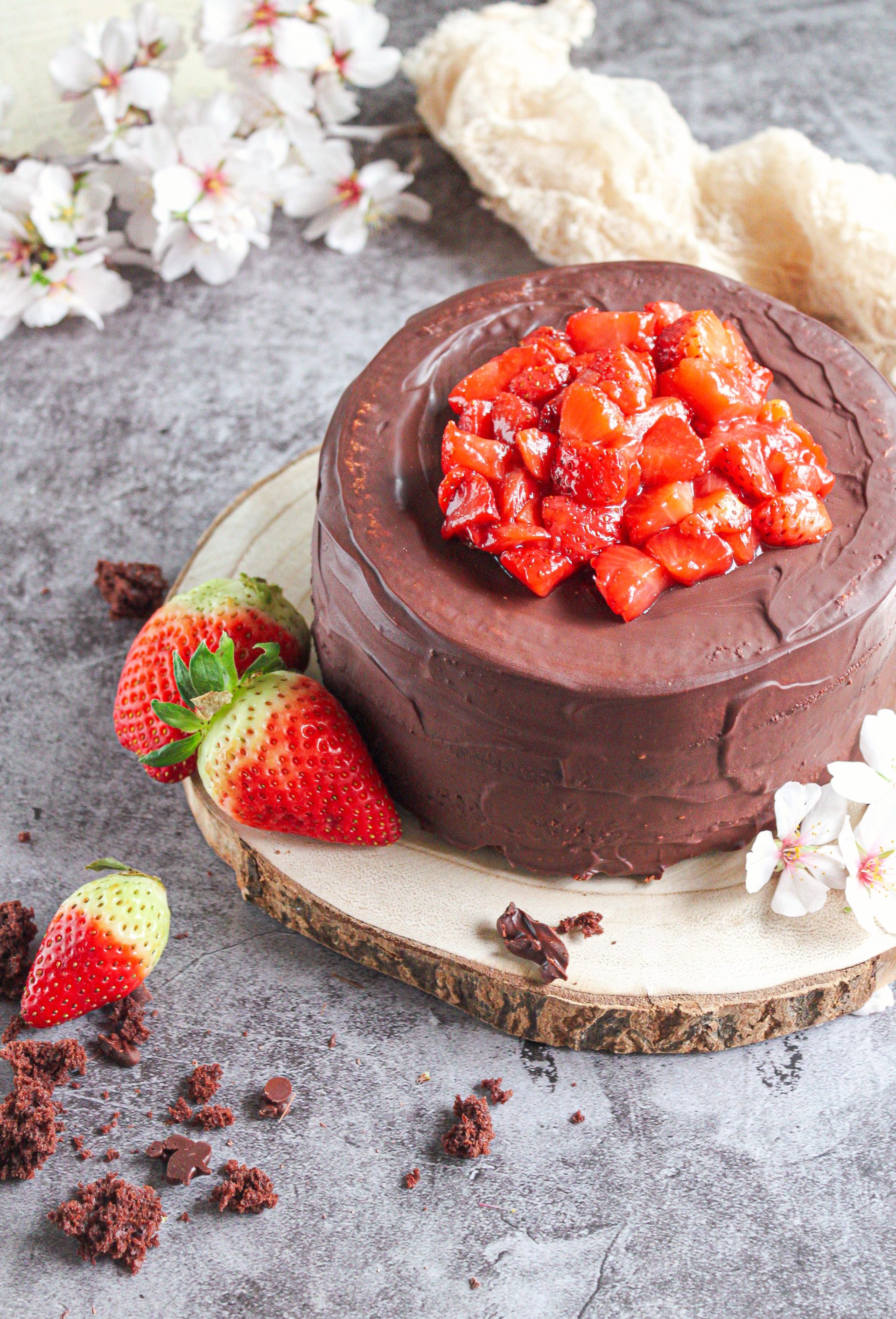 Tarta damero cubierta con glaseado de chocolate brillante y fresas confitadas en la base