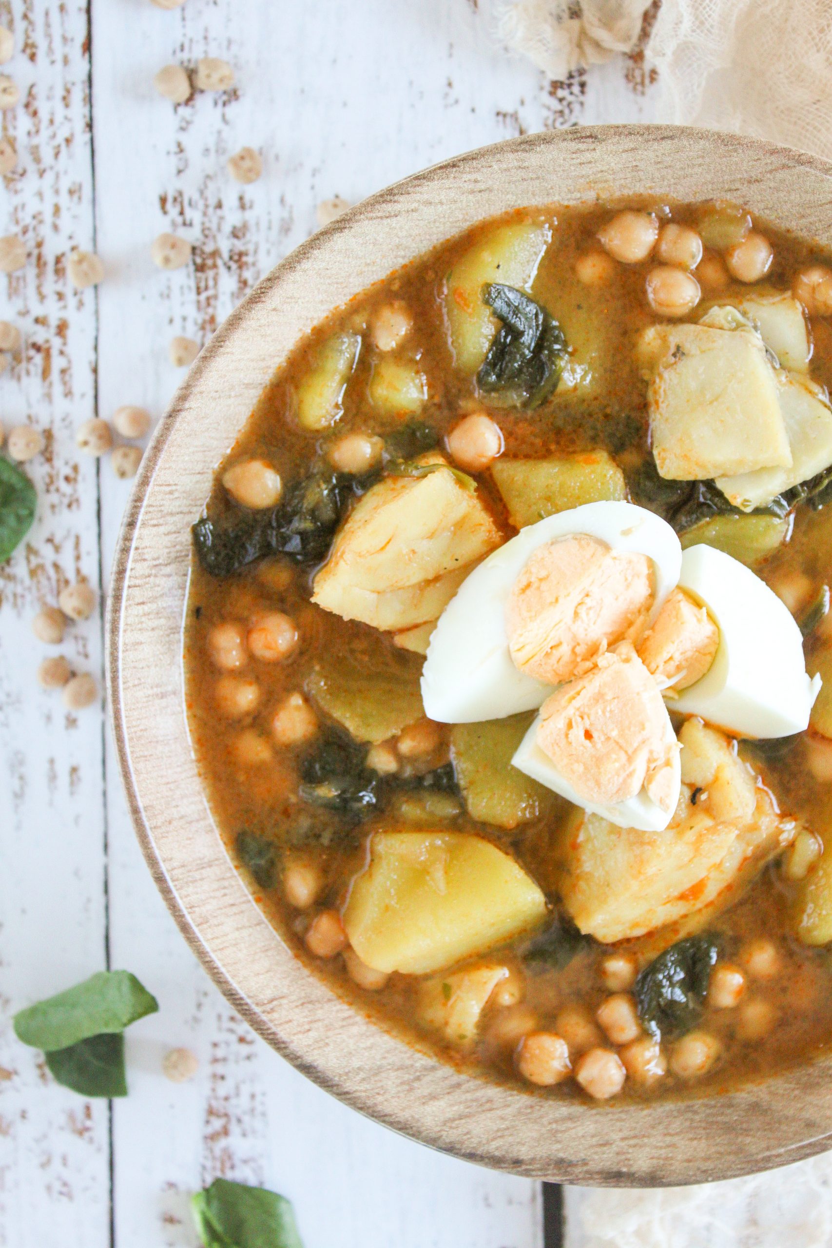 Imagen de Portada (El plato servido): Plato hondo de potaje de vigilia tradicional con garbanzos, bacalao jugoso, espinacas frescas y huevo duro picado.