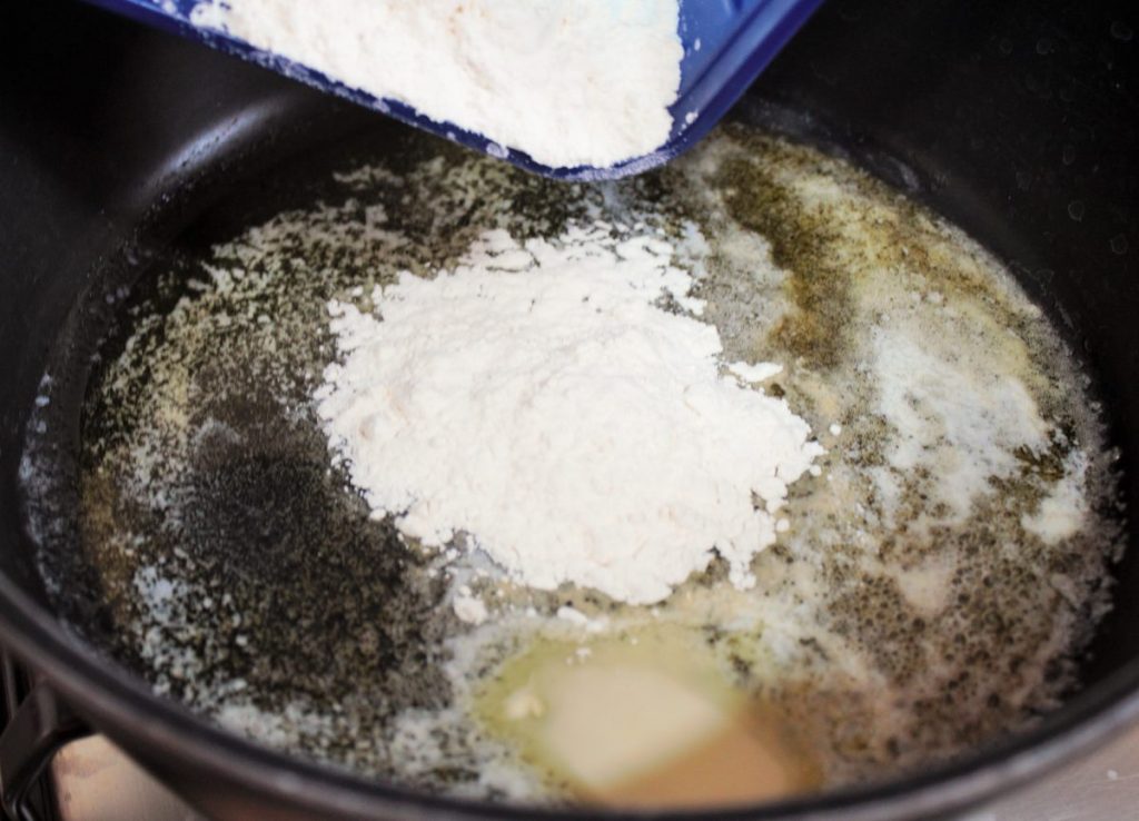 Cocinando el roux de mantequilla y harina en una sart&eacute;n para eliminar el sabor a crudo