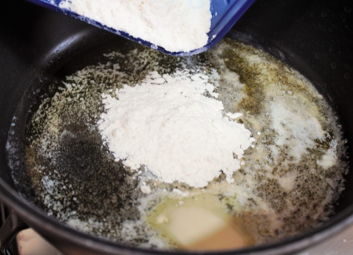 Cocinando el roux de mantequilla y harina en una sartén para eliminar el sabor a crudo