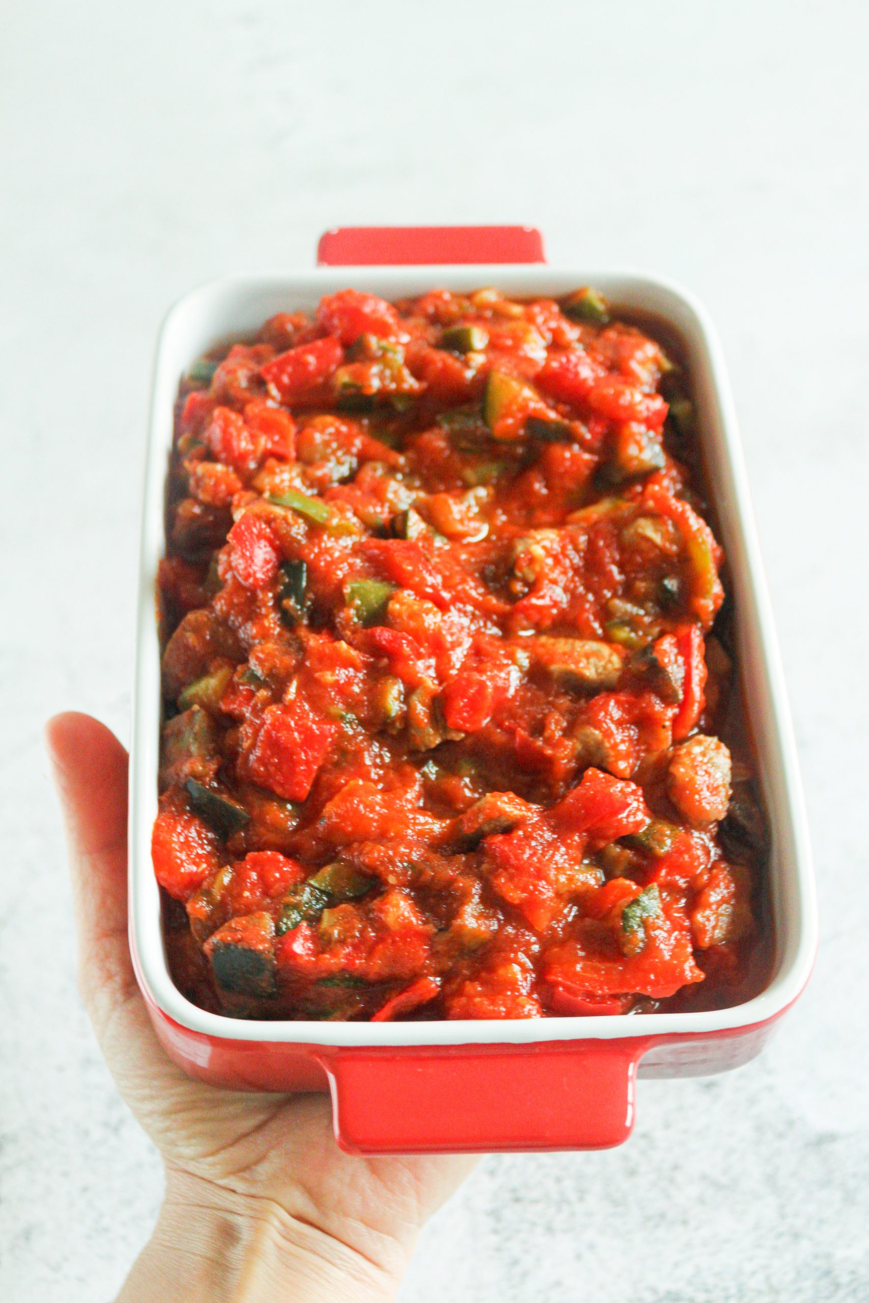 Primer plano de Sanfaina con pavo terminada, con brillo del aceite y hierbas provenzales.