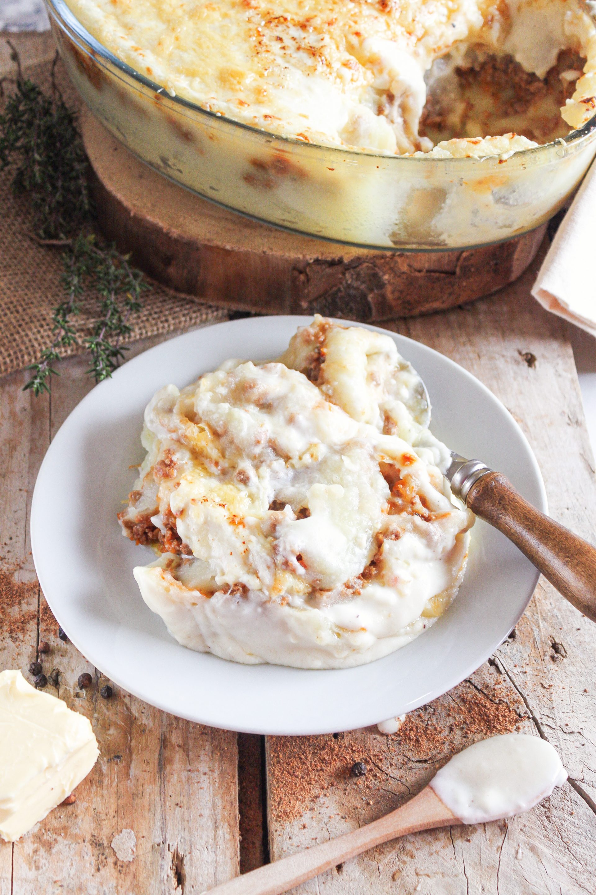 Ración de pastel de patata y carne gratinado servido en plato rústico de cocina con alma
