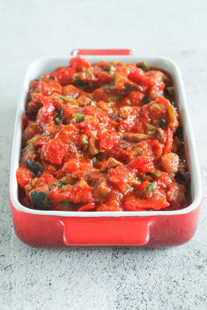 Primer plano de Sanfaina con pavo terminada, con brillo del aceite y hierbas provenzales.