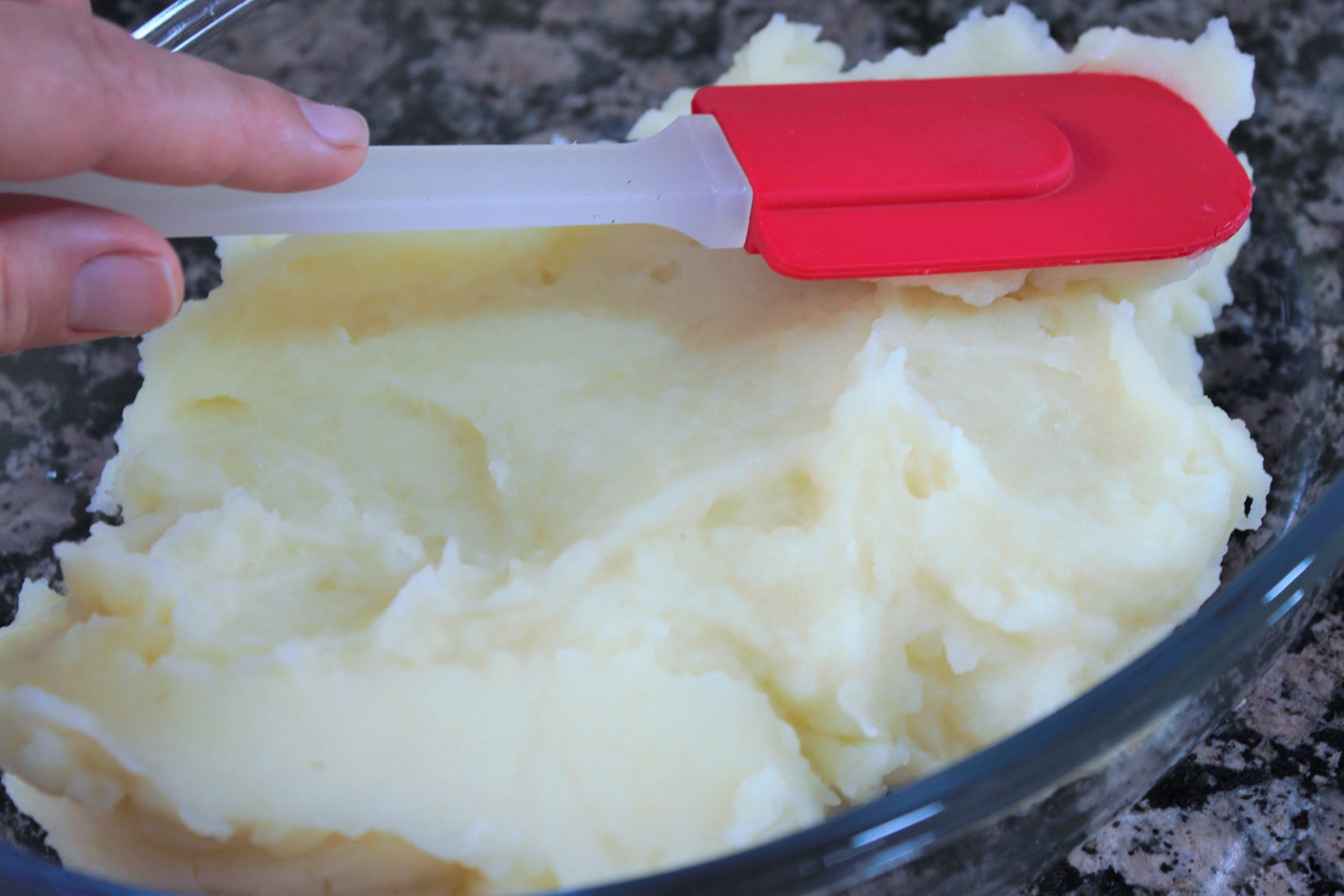 Montaje de capas de puré de patata y carne en fuente para horno
