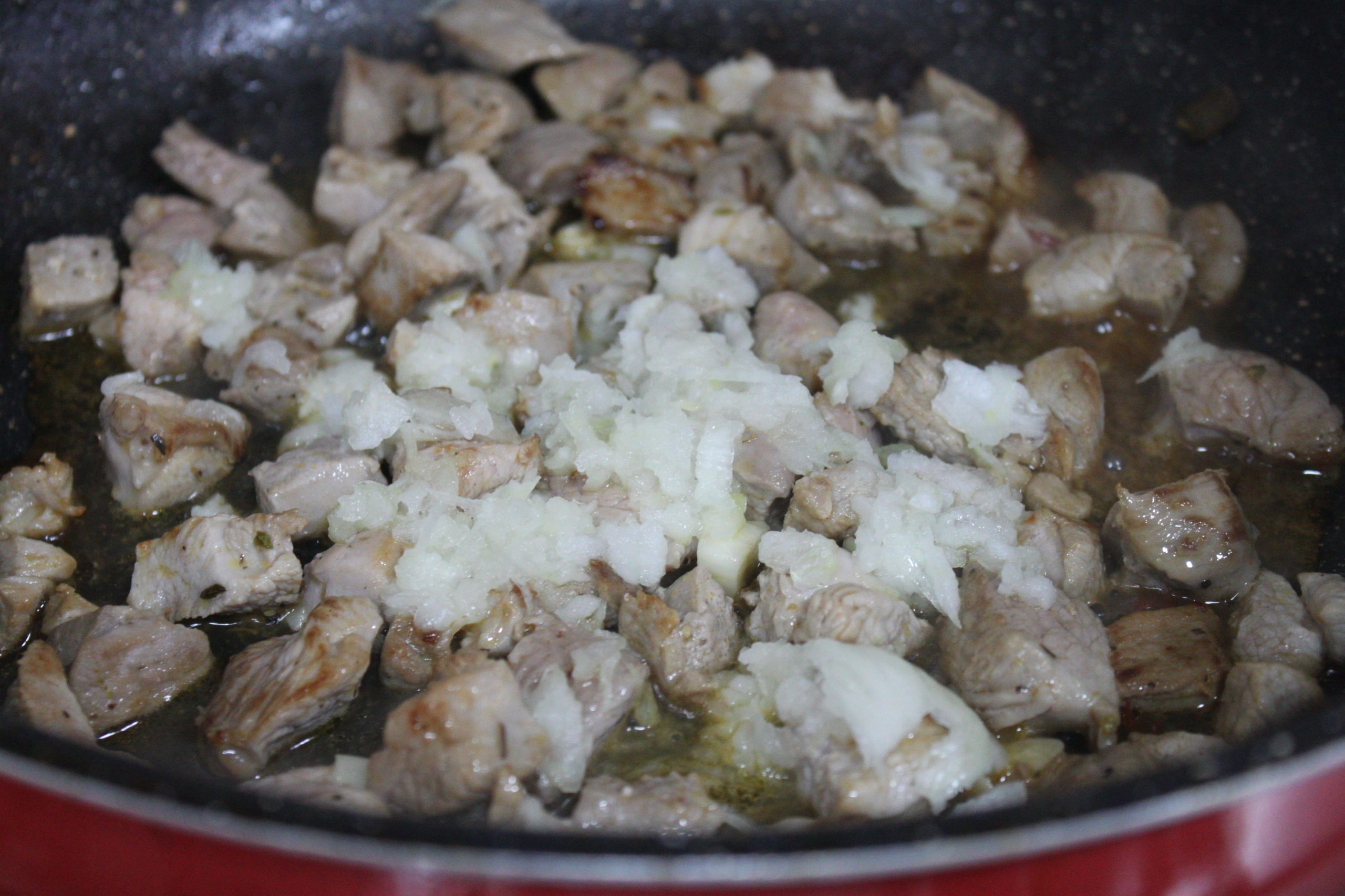 Dados de pavo dorados con ajo y cebolla rallada caramelizada a fuego lento.