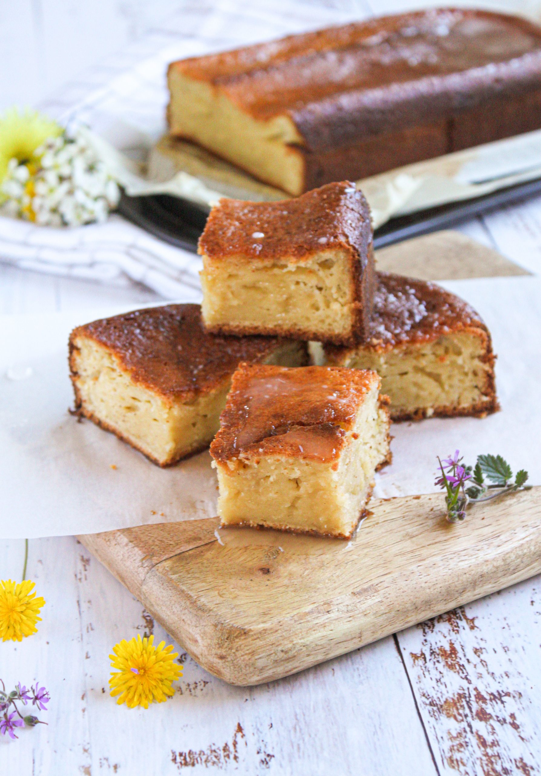 Bizcocho de yogur y almendra esponjoso con glaseado de lim&oacute;n blanco sobre rejilla r&uacute;stica.