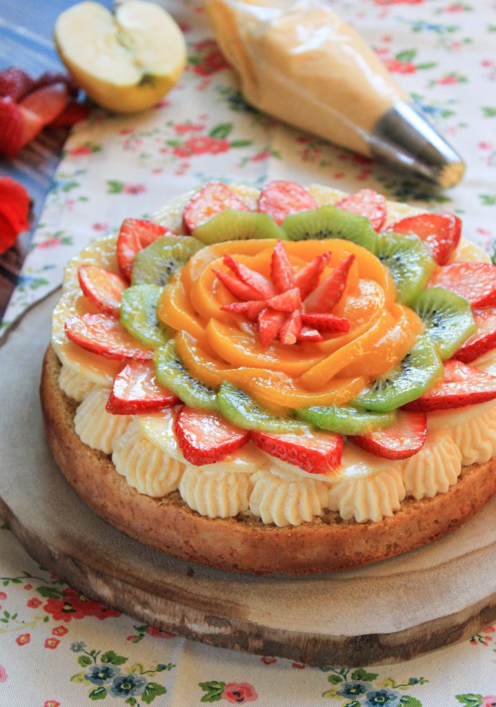 Tarta casera de crema pastelera decorada con una selección de frutas frescas de temporada, servida en un plato elegante sobre una mesa de madera.