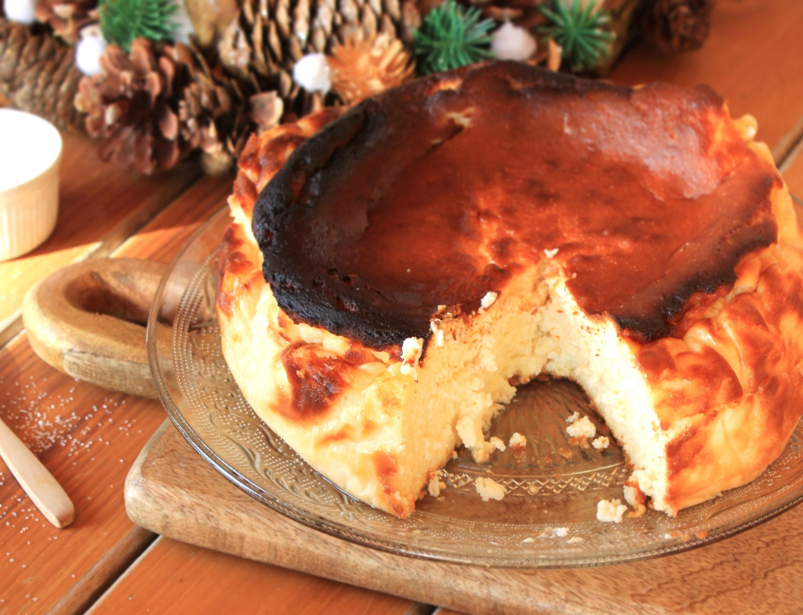 Tarta de queso La Vi&ntilde;a casera con superficie tostada y centro ultra cremoso sobre tabla de madera estilo r&uacute;stico Soulfood