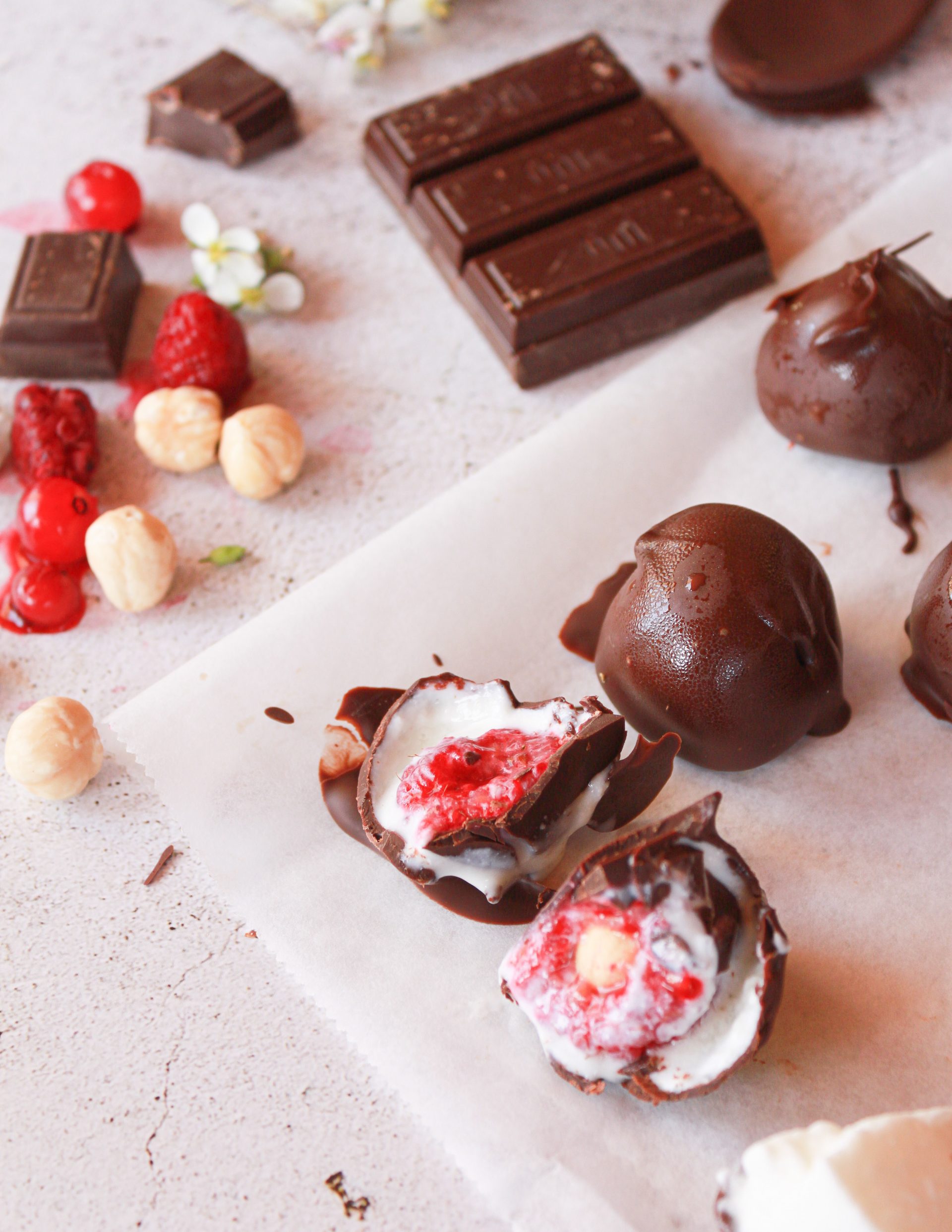 Detalle del interior de un bombón casero con frambuesa fresca, yogur y cobertura de chocolate negro
