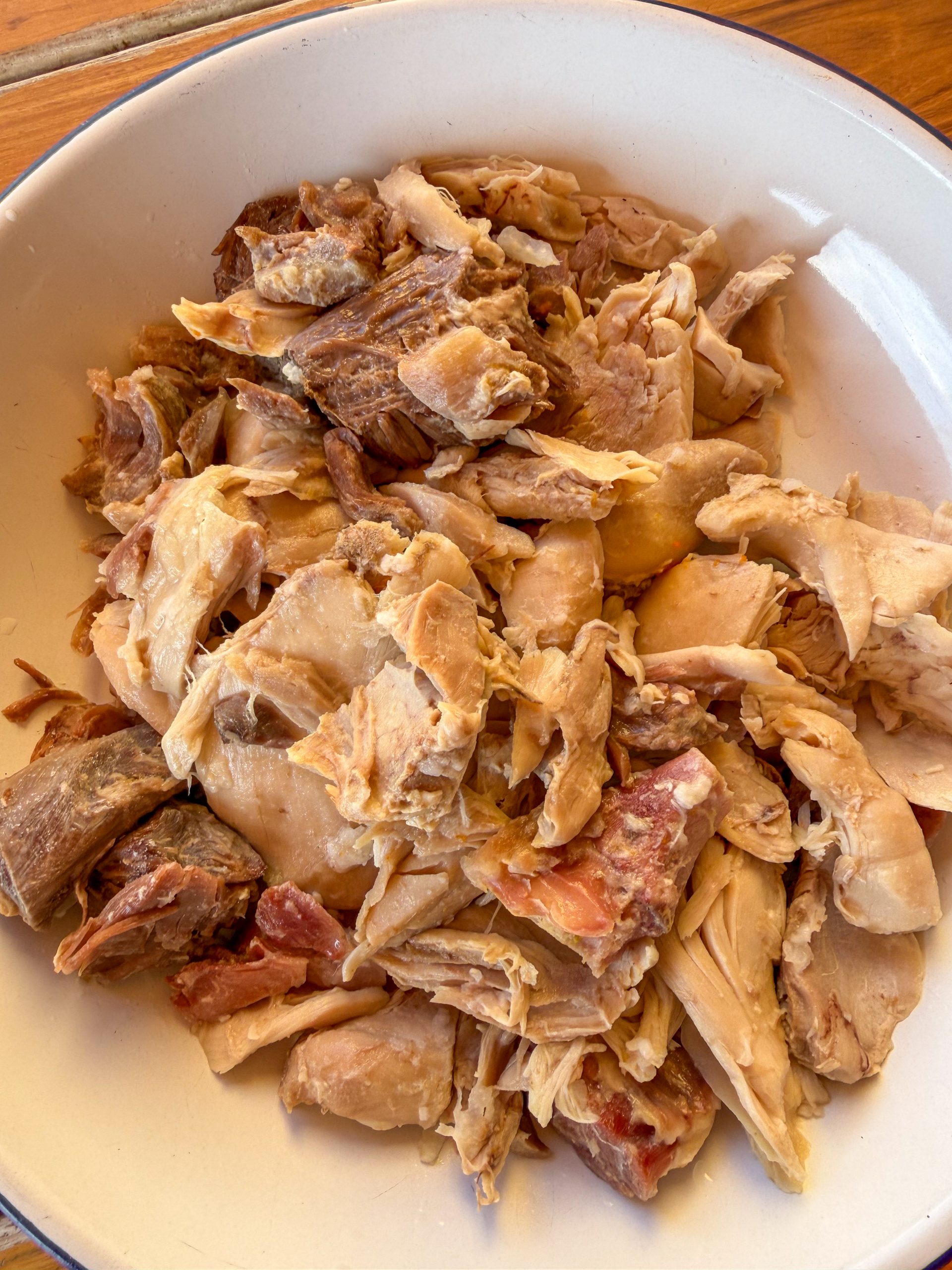 Carne del cocido desmenuzada a mano en una fuente, listo para preparar unas croquetas caseras cremosas y llenas de sabor.