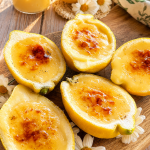 Postre de limones naturales rellenos de crema de limón suave y esponjosa sobre una mesa de madera rústica estilo soulfood