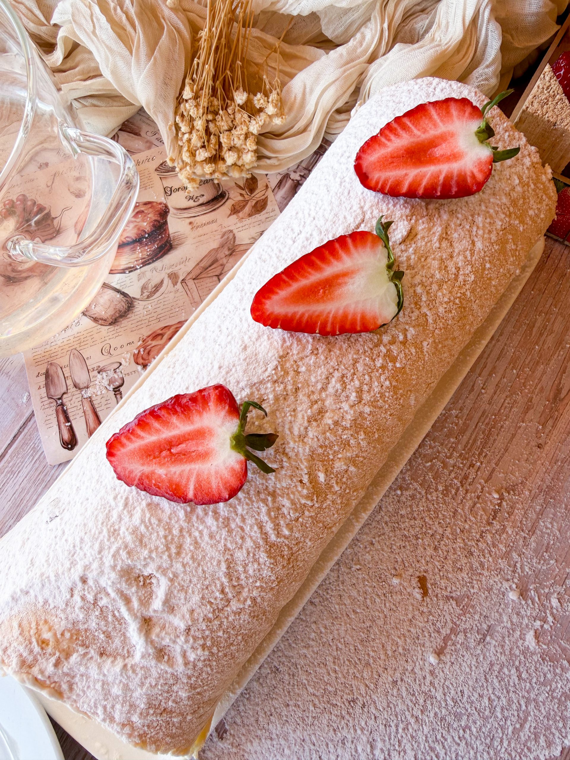 Primer plano de un bizcocho enrollado relleno de nata firme y trozos de fresas frescas naturales.