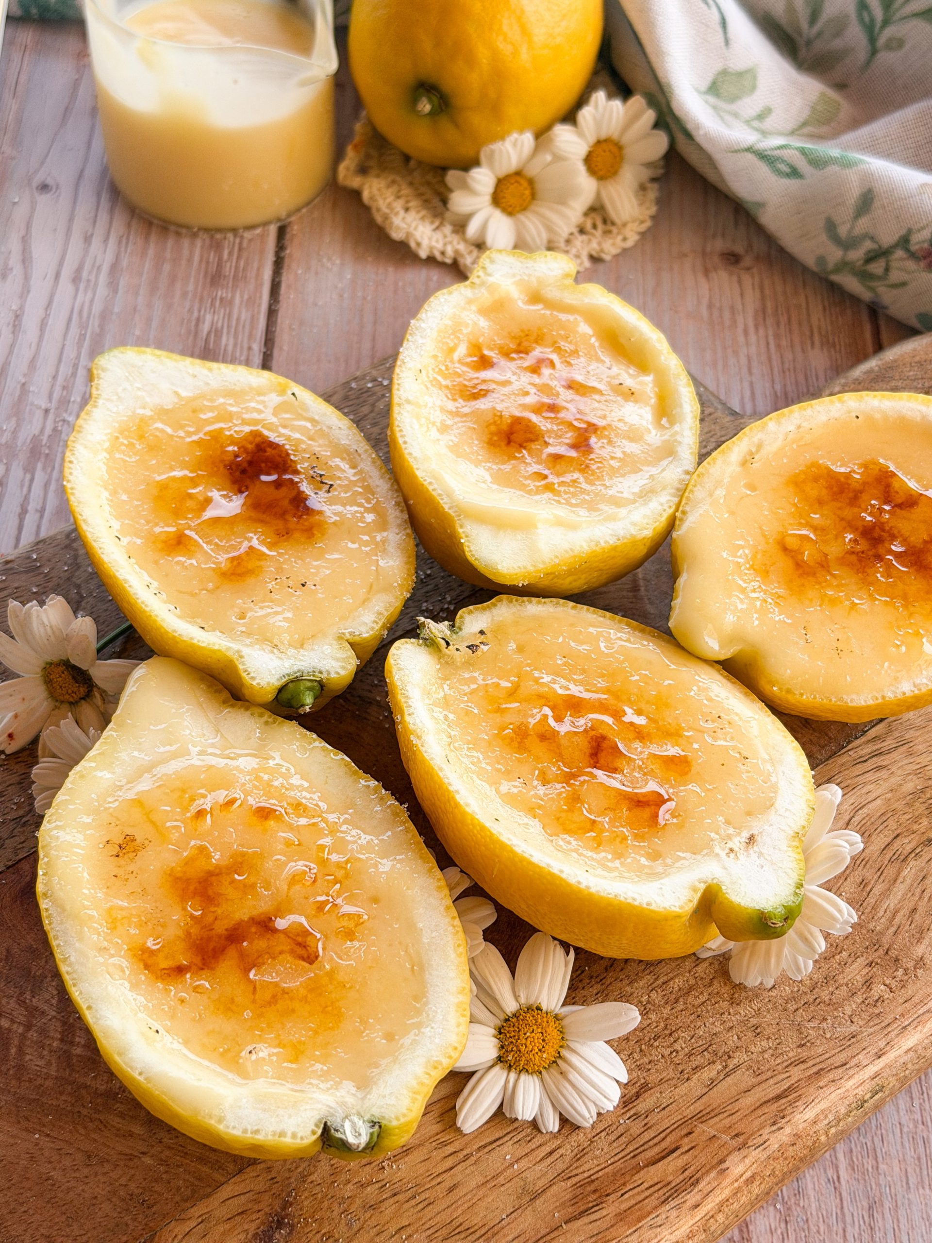 Postre de limones naturales rellenos de crema de limón suave y esponjosa sobre una mesa de madera rústica estilo soulfood