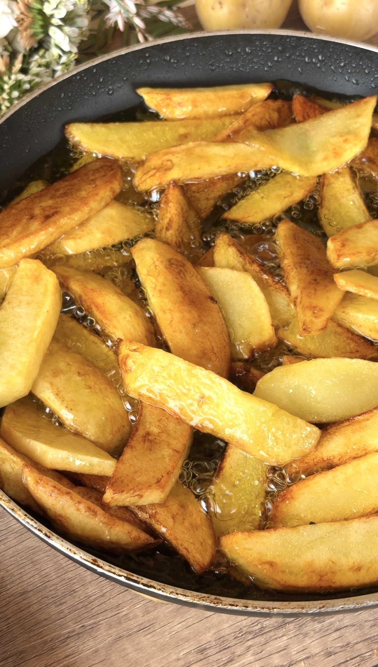 Patatas friéndose en abundante aceite