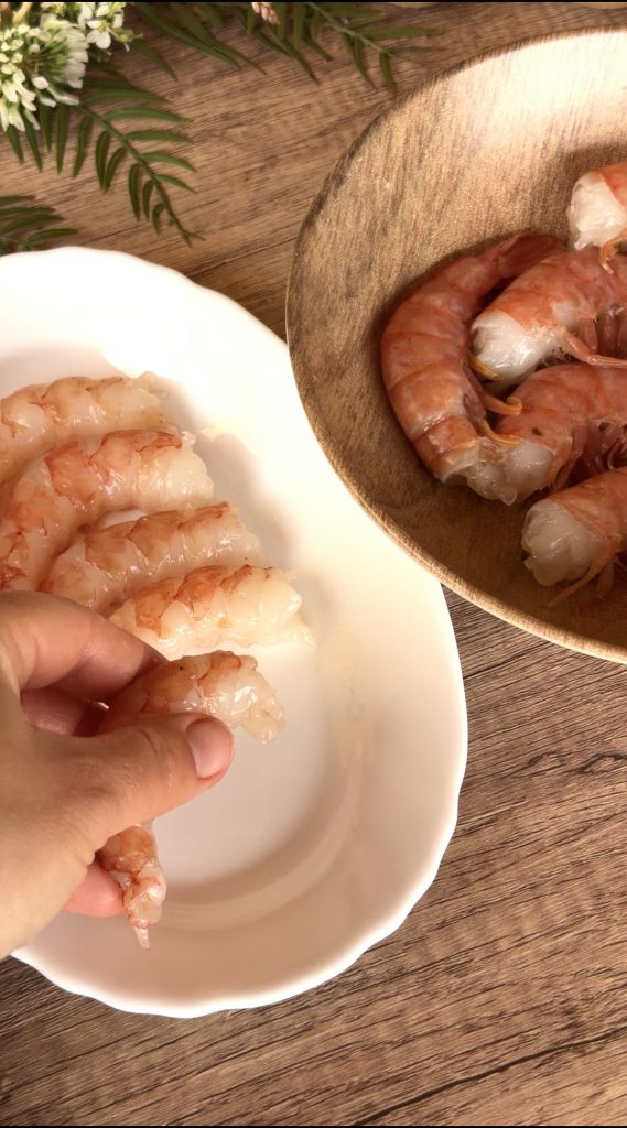 Limpiando los gambones pel&aacute;ndolos y retirando el intestino para que queden bien limpios.