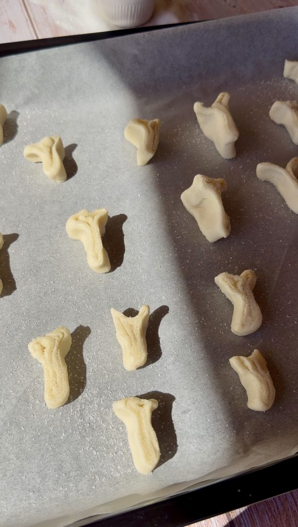 Lámina de hojaldre rectangular extendida sobre una superficie cubierta de azúcar blanco, lista para ser enrollada.