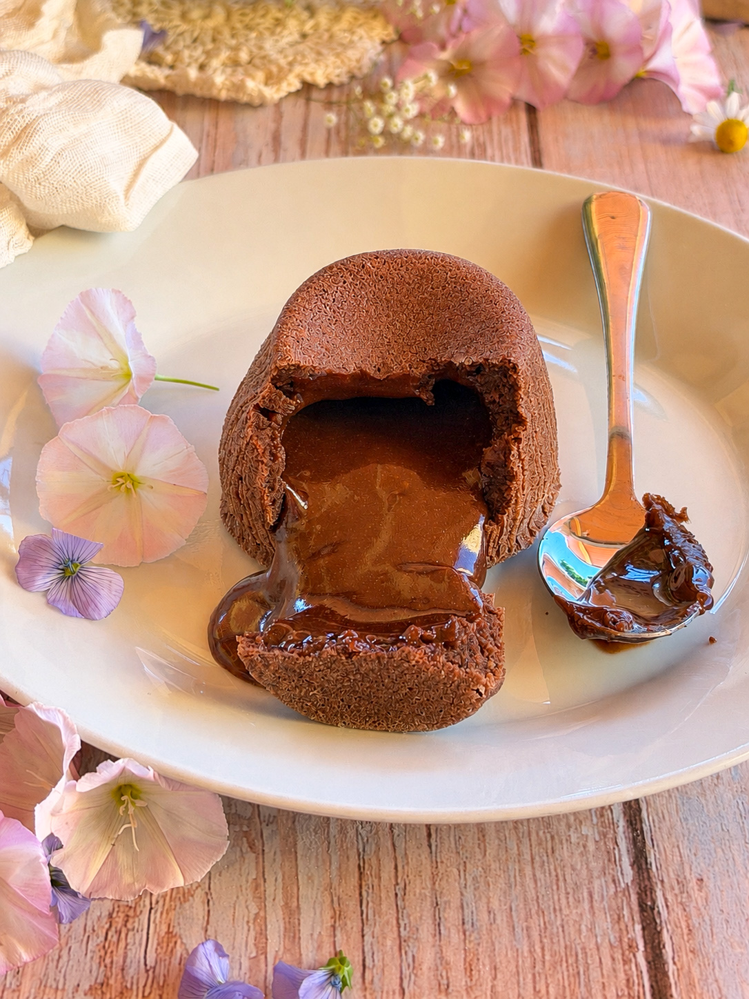 Coulant de chocolate casero con el interior fluido y fundente servido en un plato de cerámica, estilo cocina artesanal.