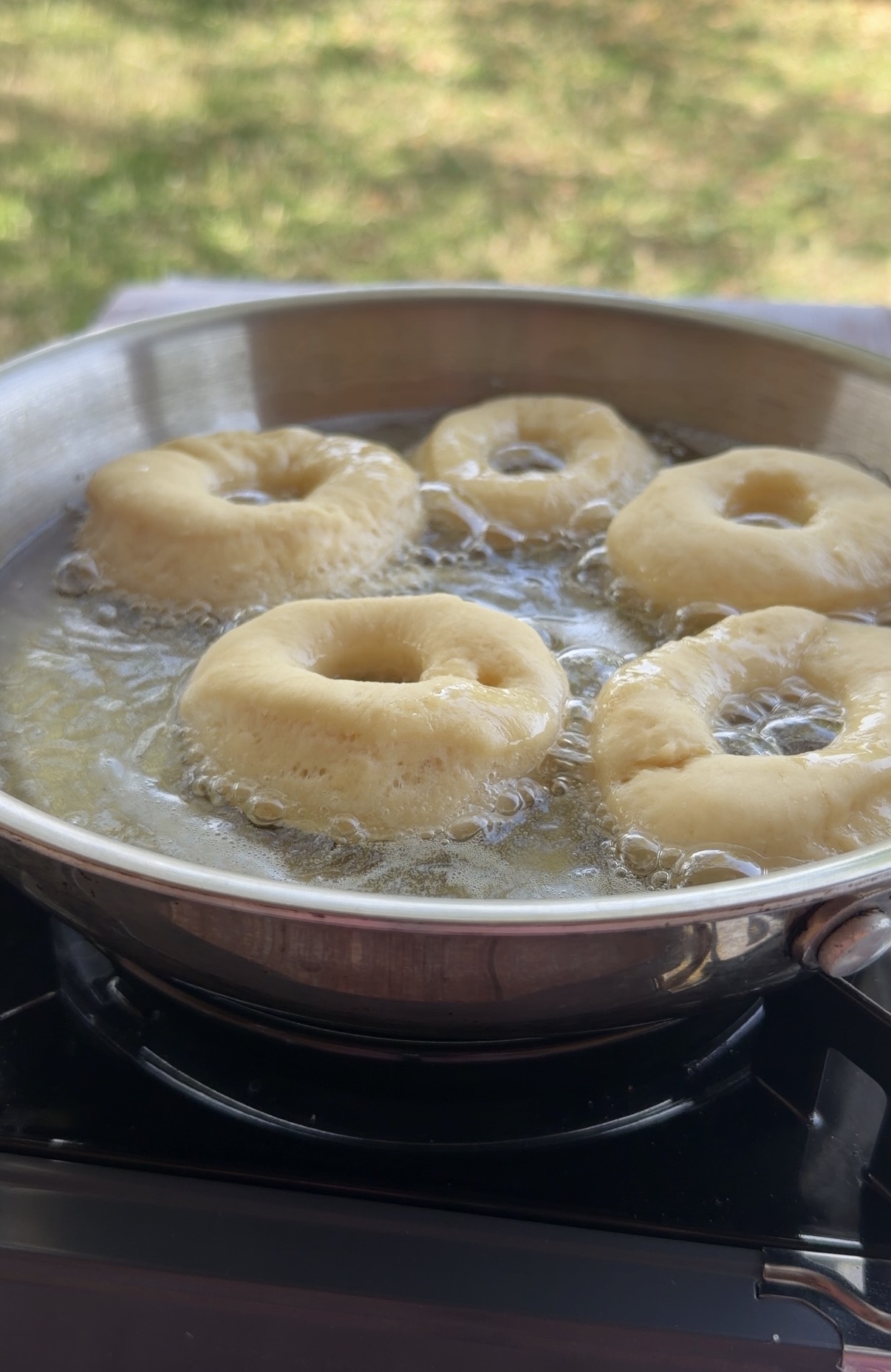 Donuts caseros dorándose en aceite en una sartén