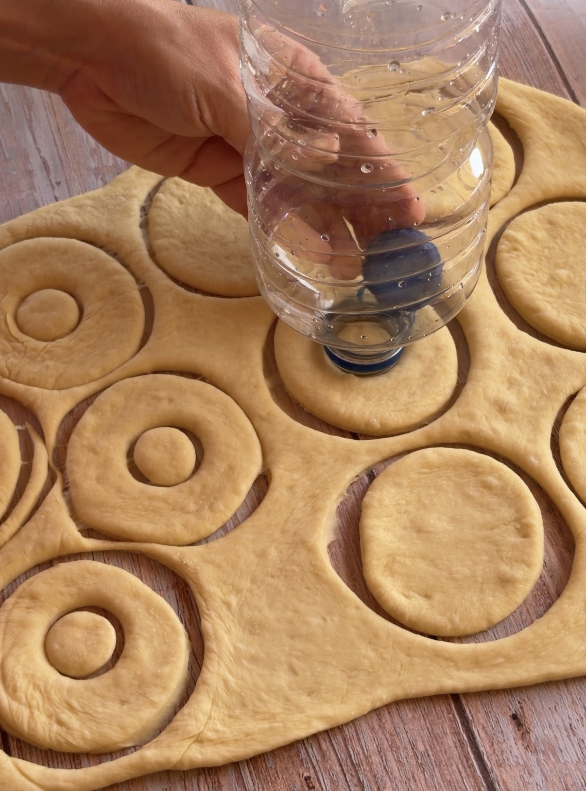 Donuts crudos cortados sobre papel de horno antes de la segunda fermentación