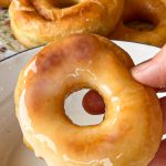 Donut glaseado brillando en una mano