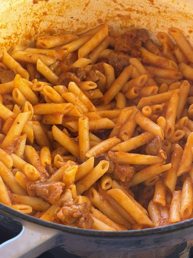 Plato de macarrones finos con carne de la abuela y queso emmental fundido, servidos en plato rústico