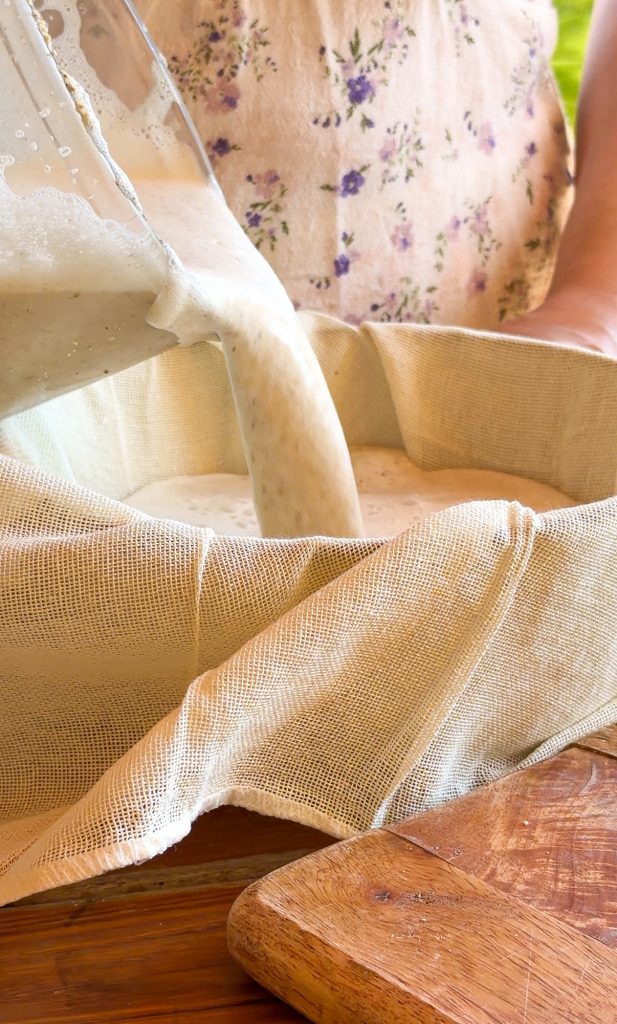 Proceso de elaboración de horchata casera donde se vierte la mezcla triturada de chufas desde una batidora sobre un paño de tela para el filtrado.