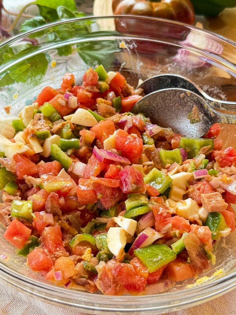 Bol de cristal con pipirrana andaluza tradicional recién hecha, mostrando el corte en brunoise del tomate maduro, pimiento verde, cebolla, atún y huevo duro.